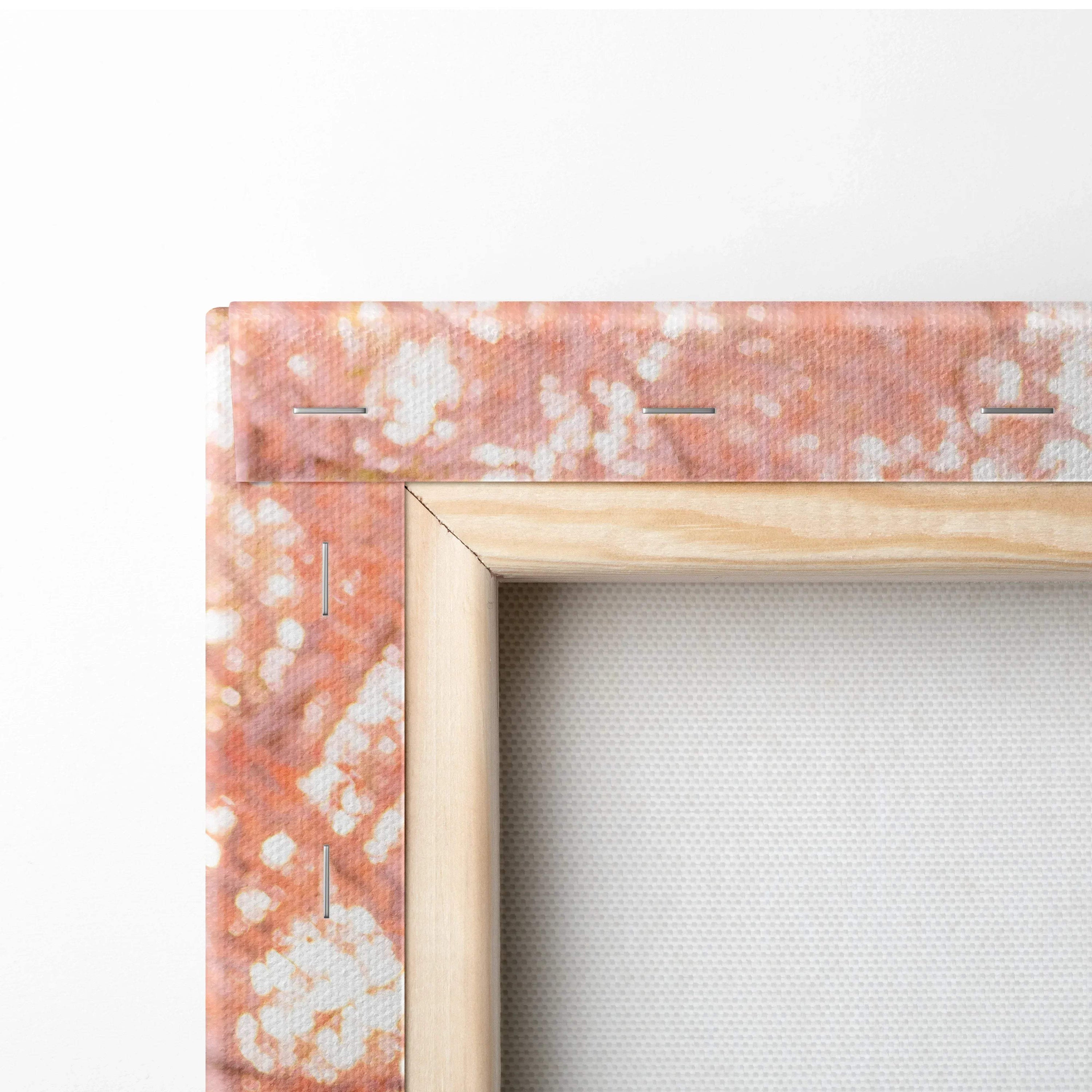 Close-up of wooden frame and stretched canvas corner with orange and white abstract print, canvas art wall decor.
