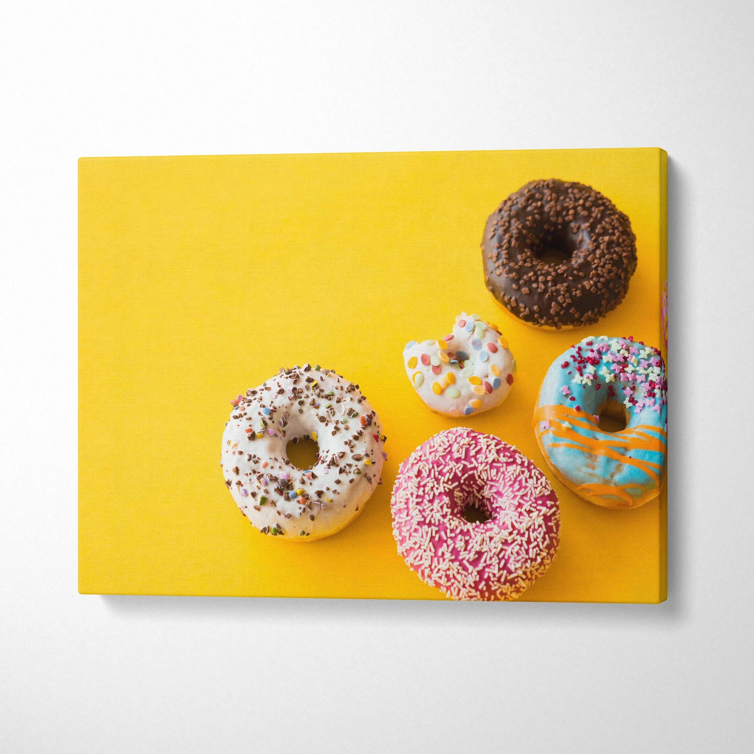 Colorful donut themed canvas wall art with vibrant glazes and sprinkles on yellow background decor.