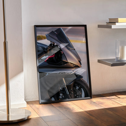 Yamaha R6 motorcycle poster wall art in black frame leaning against white wall on wooden floor.