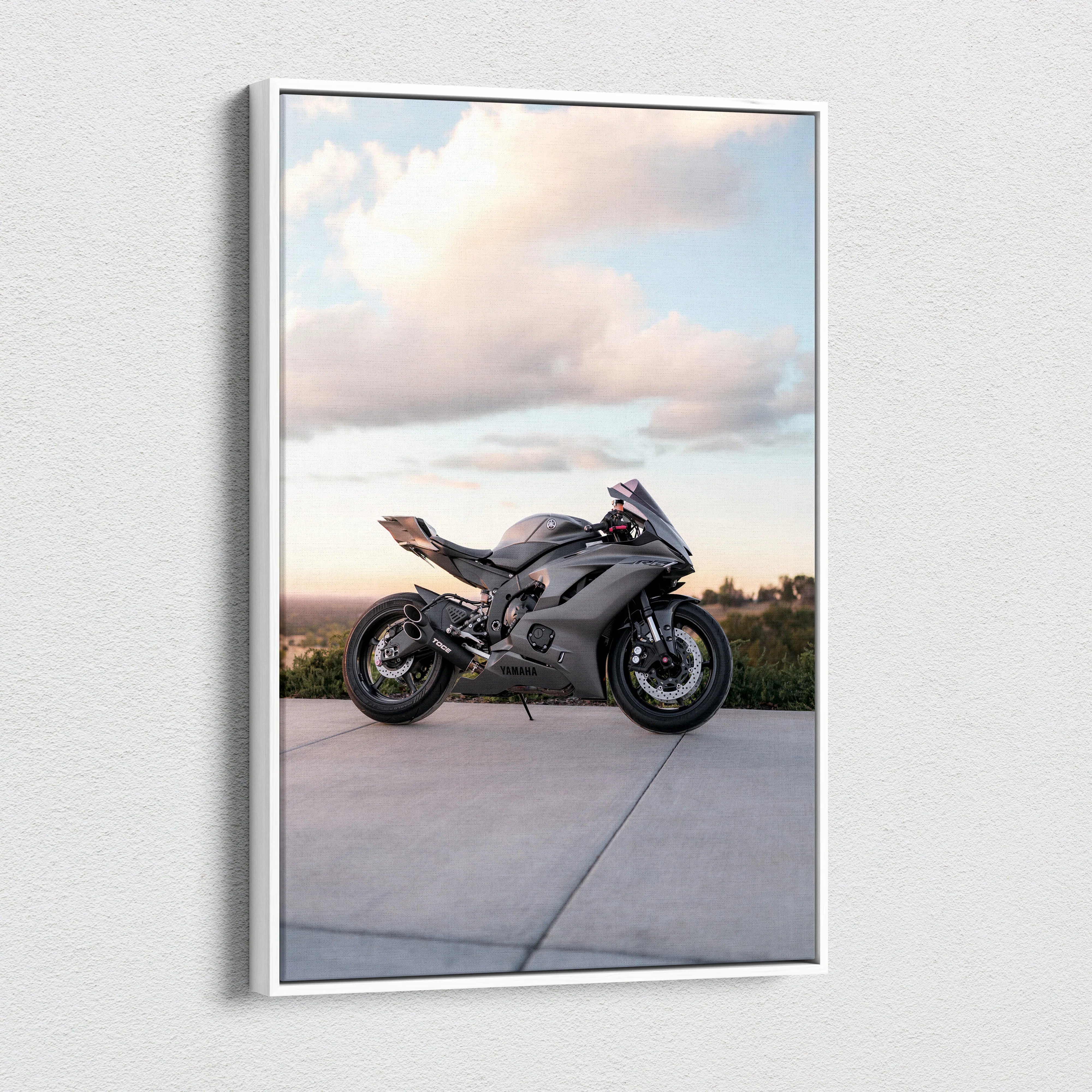 Vertical canvas art of a black Yamaha R6 motorcycle against a cloudy sky background.