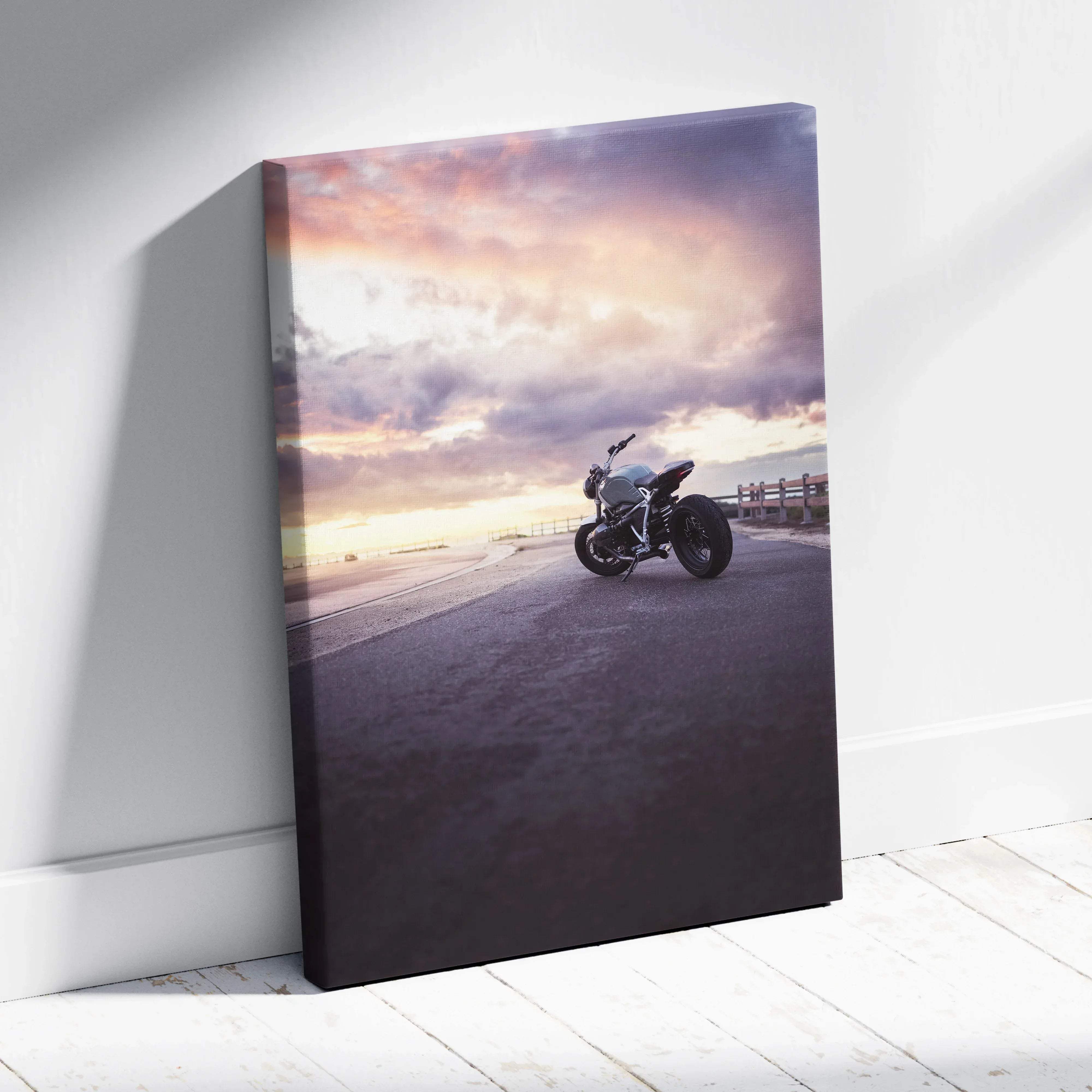 A sleek matte canvas wall art featuring a silver BMW inspired r nine t motorcycle under a pink and purple sunset sky
