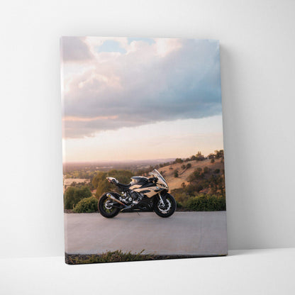 Vertical canvas wall art featuring a BMW S1000RR motorcycle against a scenic sunset background.
