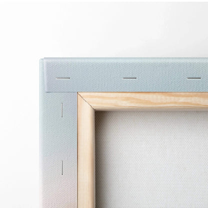 Close-up of corner of stretched canvas wall art with light wood frame and white fabric texture.