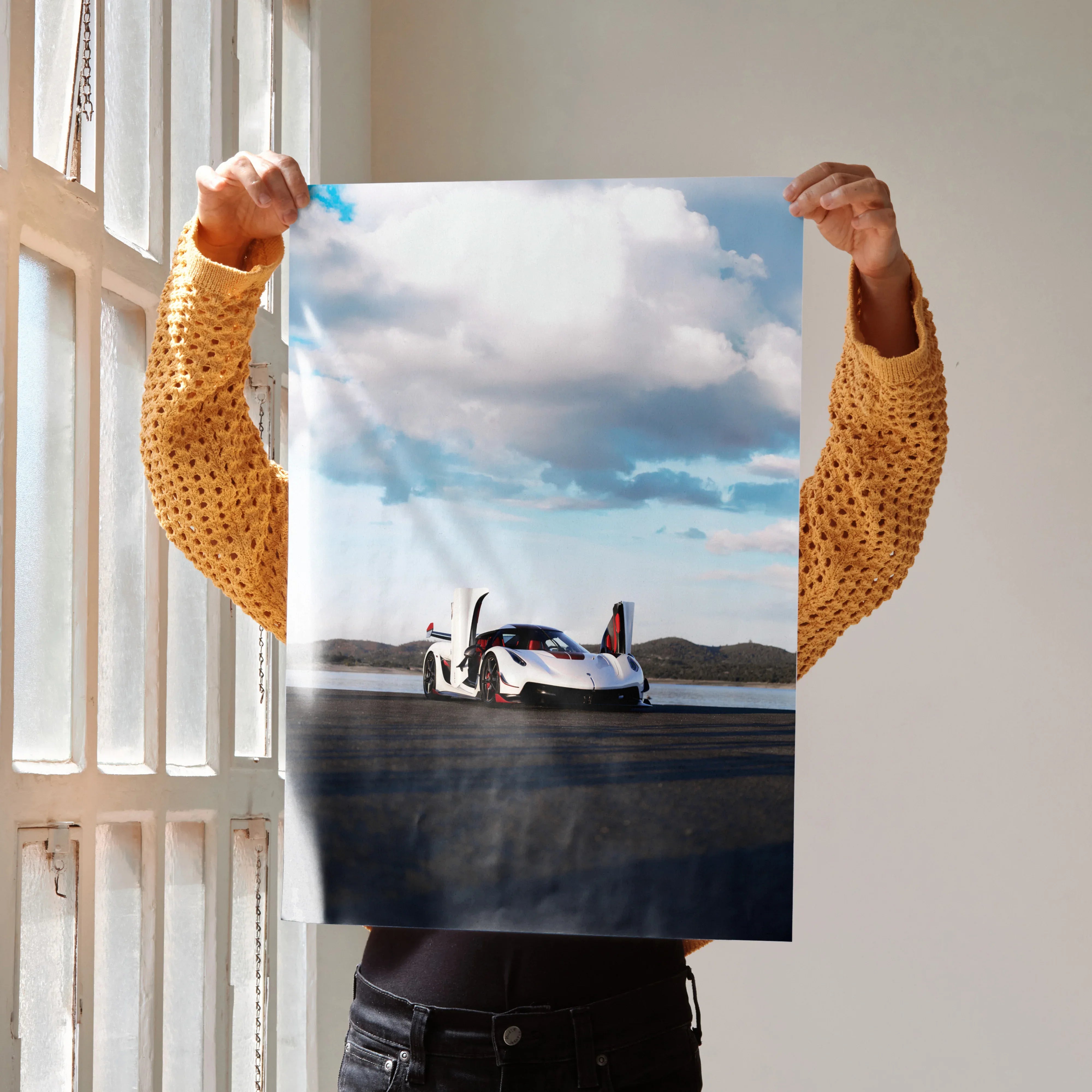 Koenigsegg Jesko poster wall art featuring a sleek white sports car under a blue sky with clouds.