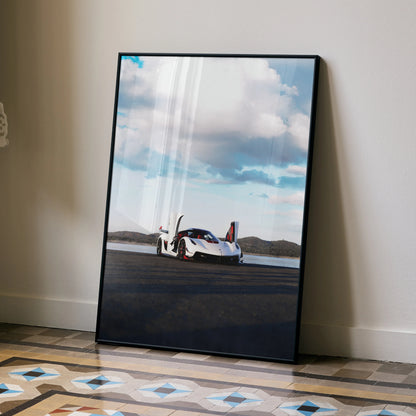 Koenigsegg Jesko high resolution car poster leaning against wall, modern black frame wall art with blue sky background.