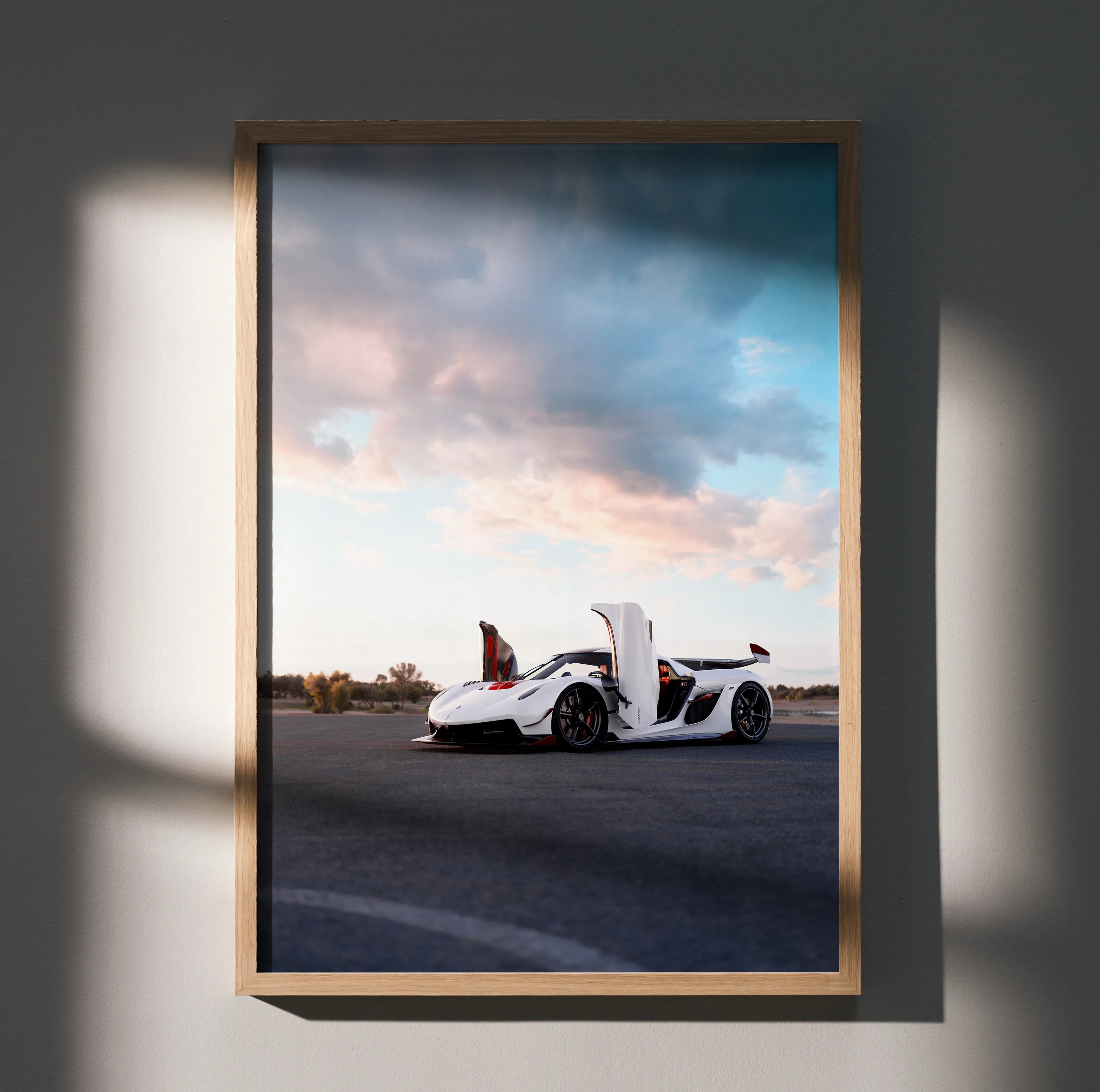Koenigsegg Jesko white sports car parked on road under dramatic sky poster wall art in wooden frame.