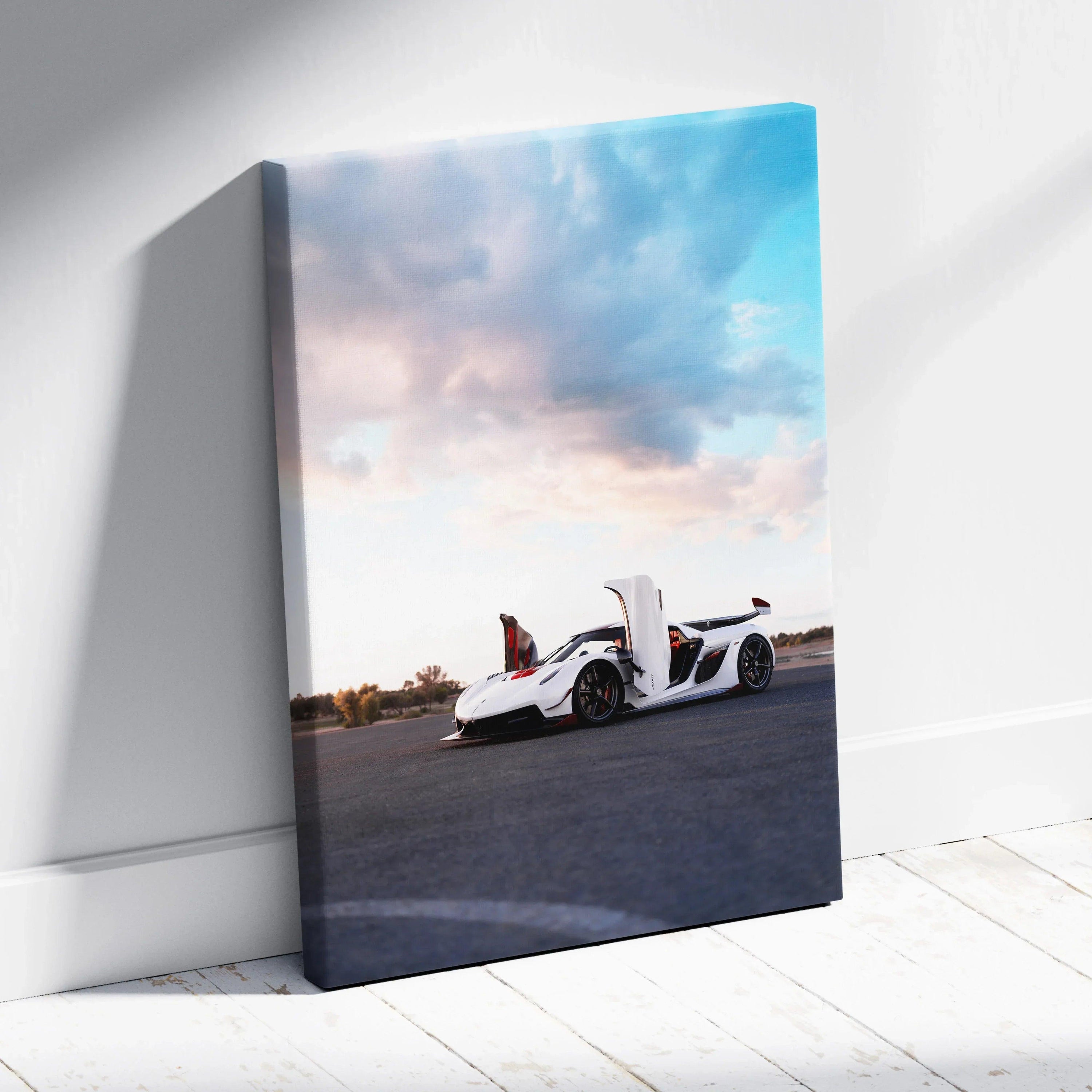 Vertical canvas wall art featuring a white Koenigsegg Jesko sports car under a blue sky with clouds.