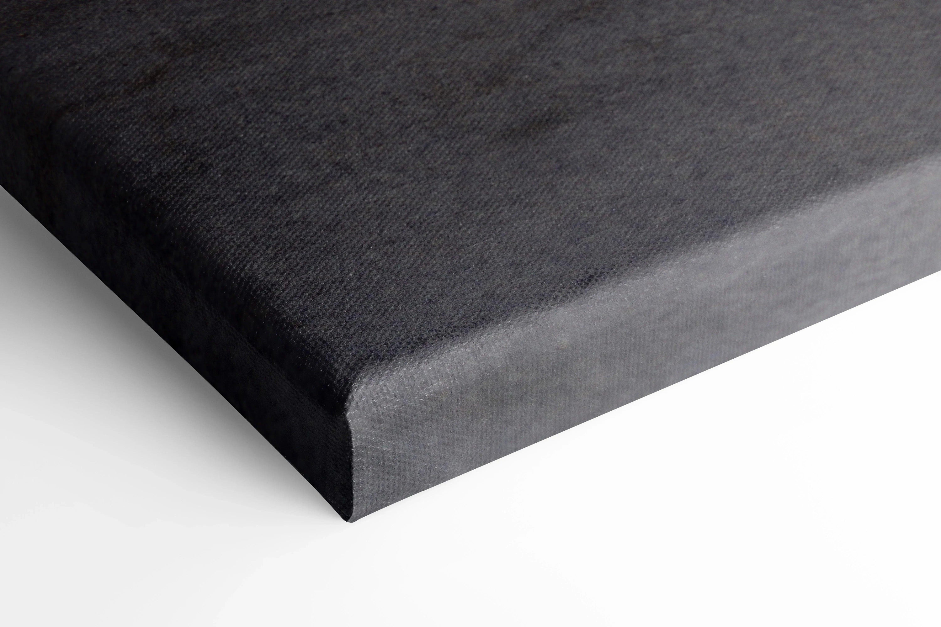 Close-up of corner of black canvas wall art with smooth textured surface and wrapped edges.