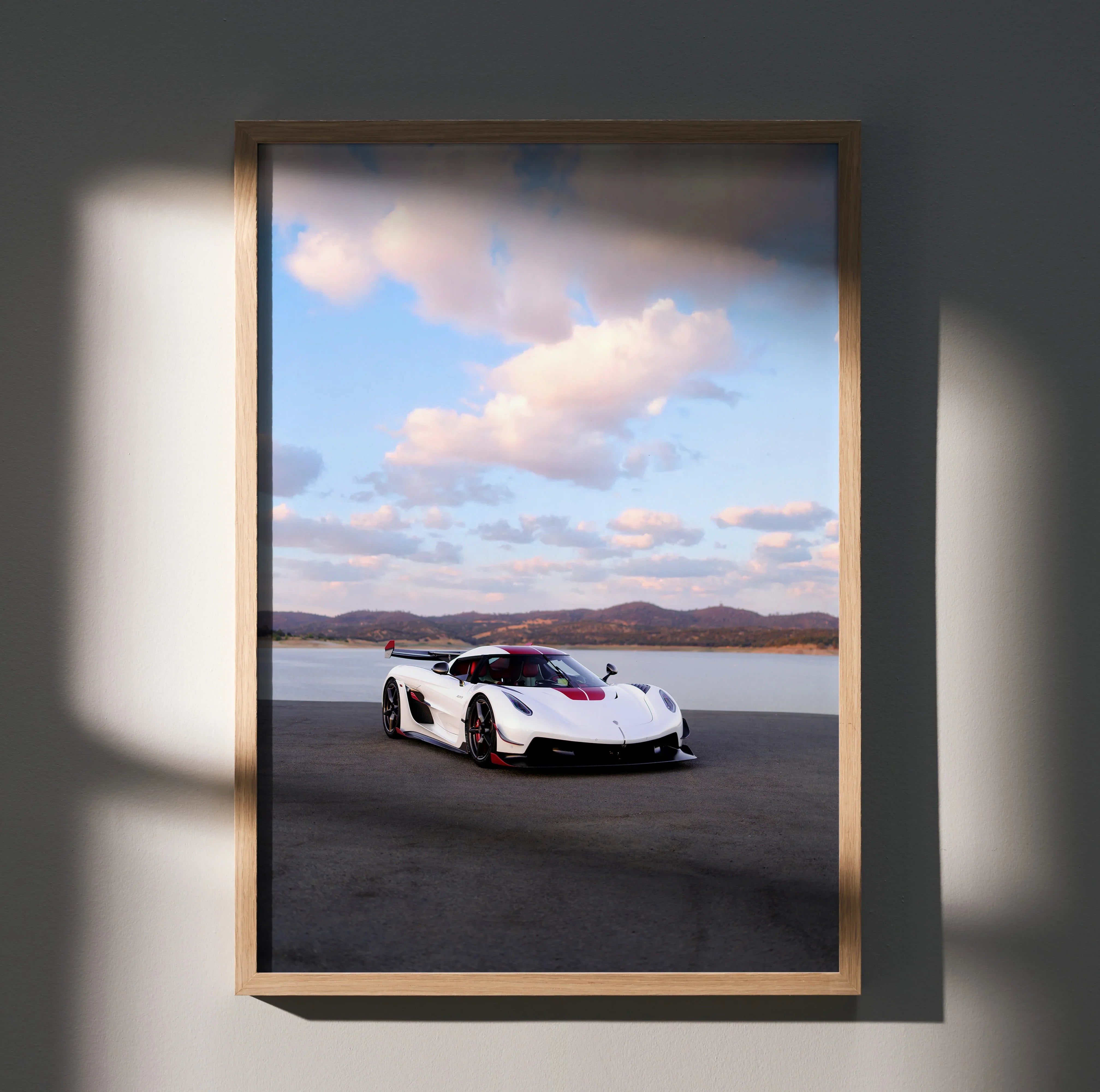 Koenigsegg Jesko sports car poster with scenic sky, framed wall art in natural light.