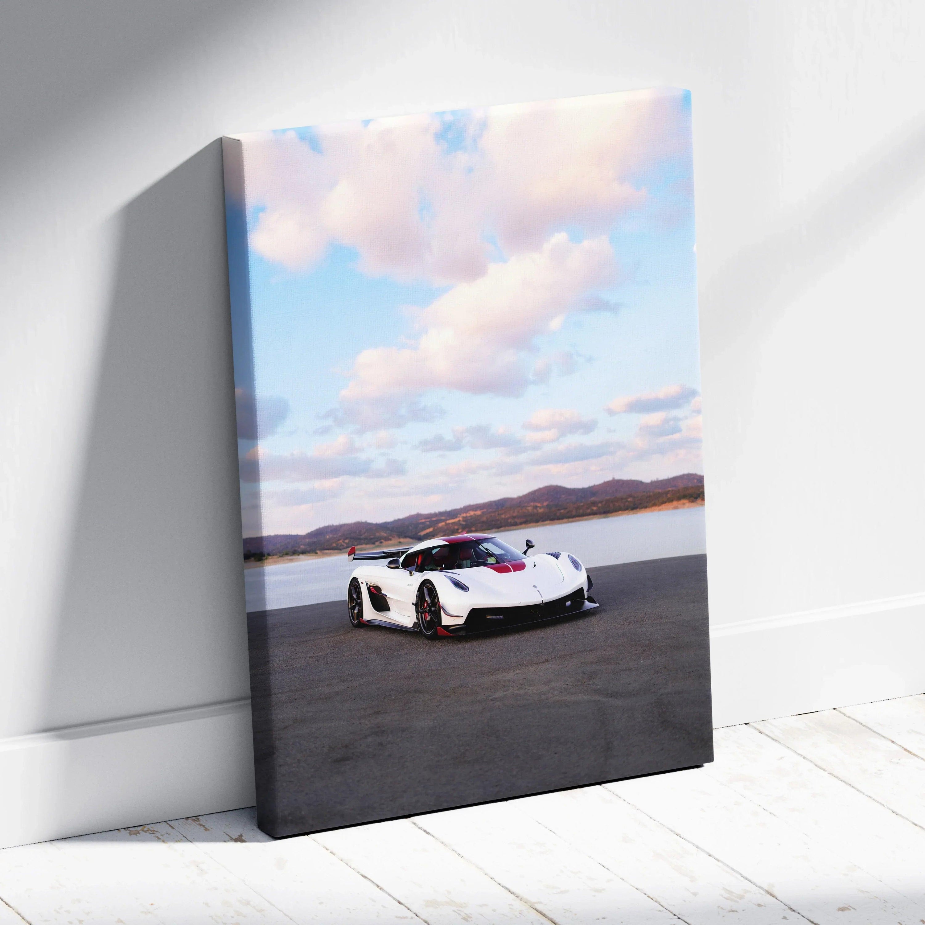 Vertical canvas wall art featuring a white Koenigsegg Jesko sports car against a cloudy sky backdrop.