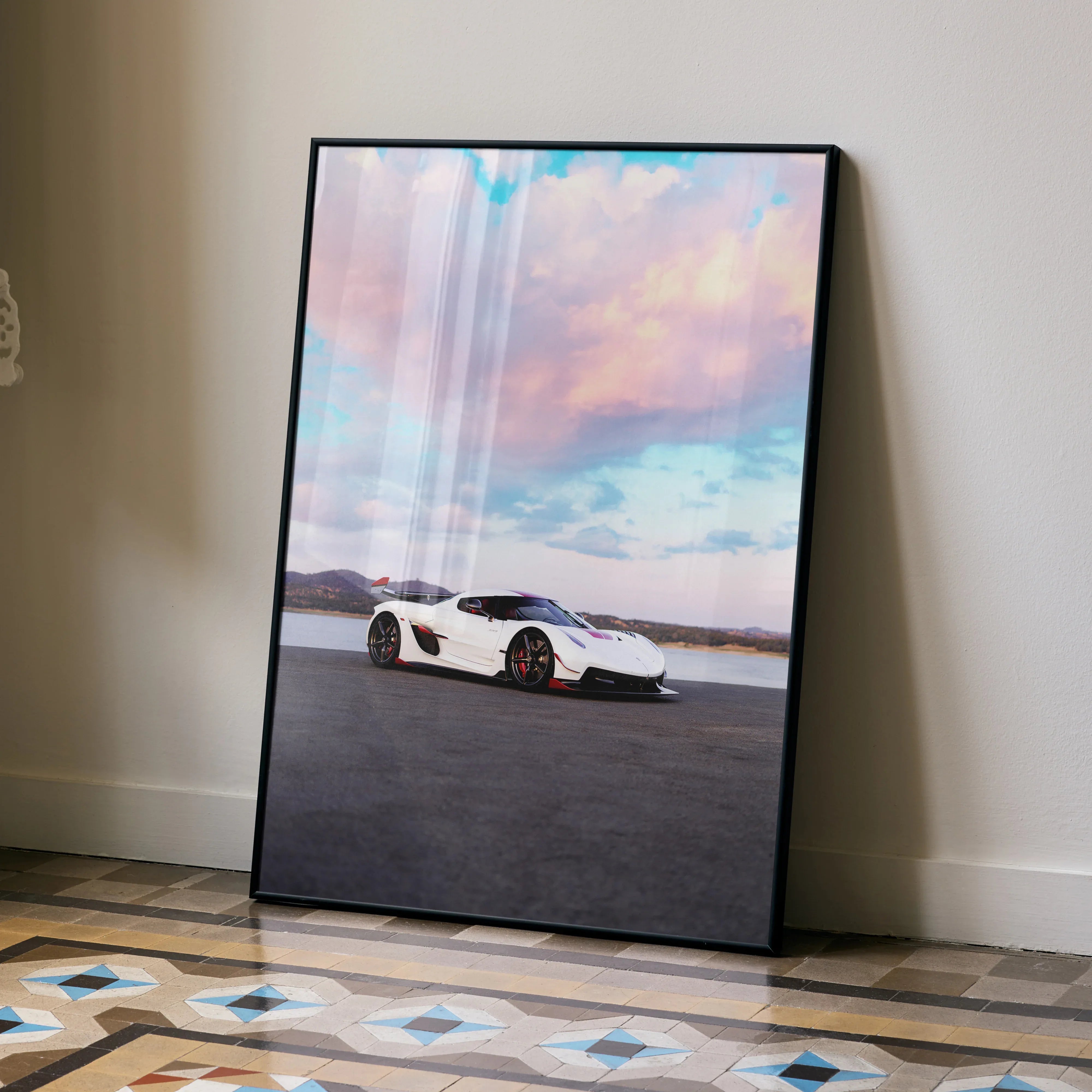 Koenigsegg Jesko car poster with white sports car and vibrant sunset sky wall art in black frame.