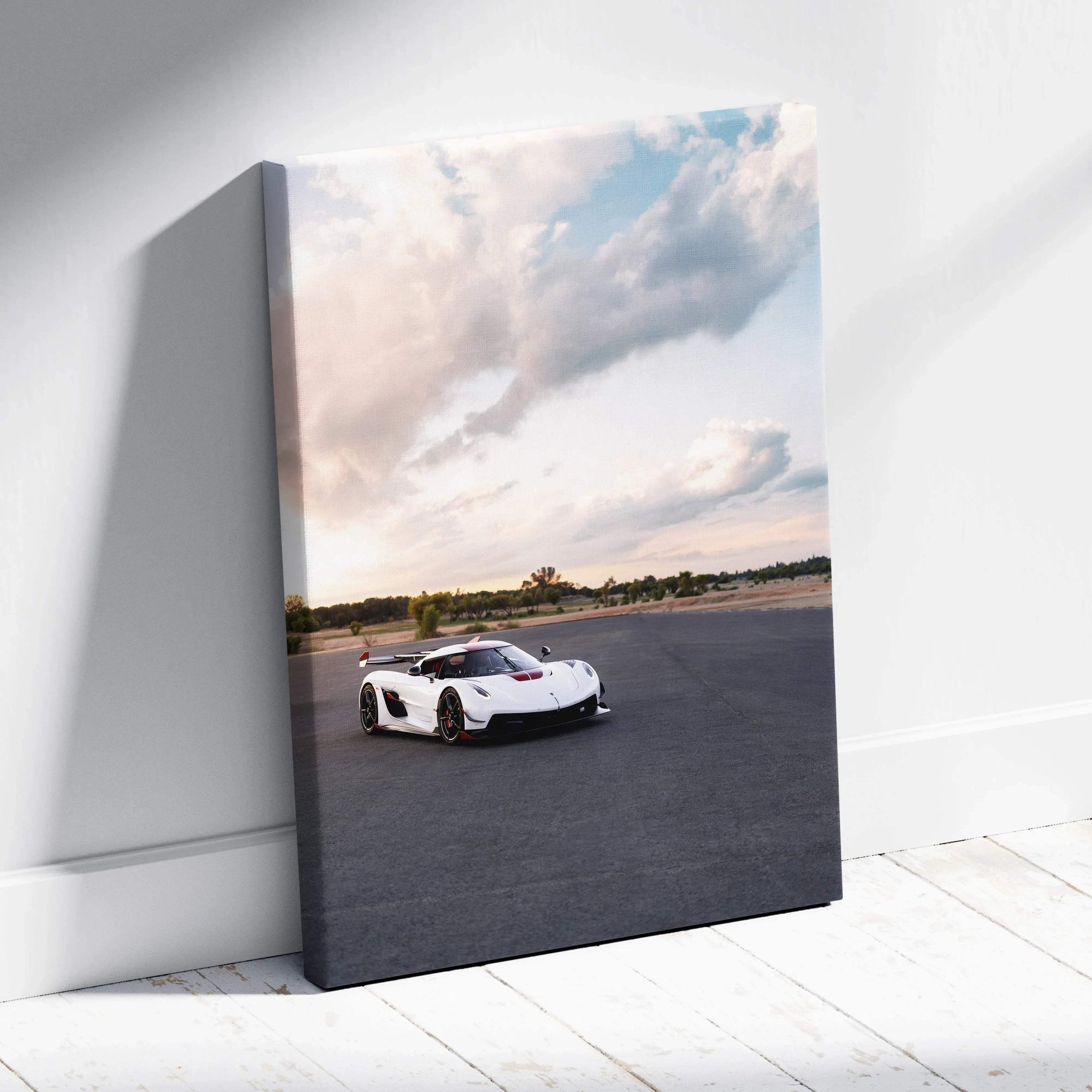 Vertical canvas wall art featuring a white Koenigsegg Jesko sports car under a cloudy sky on asphalt.