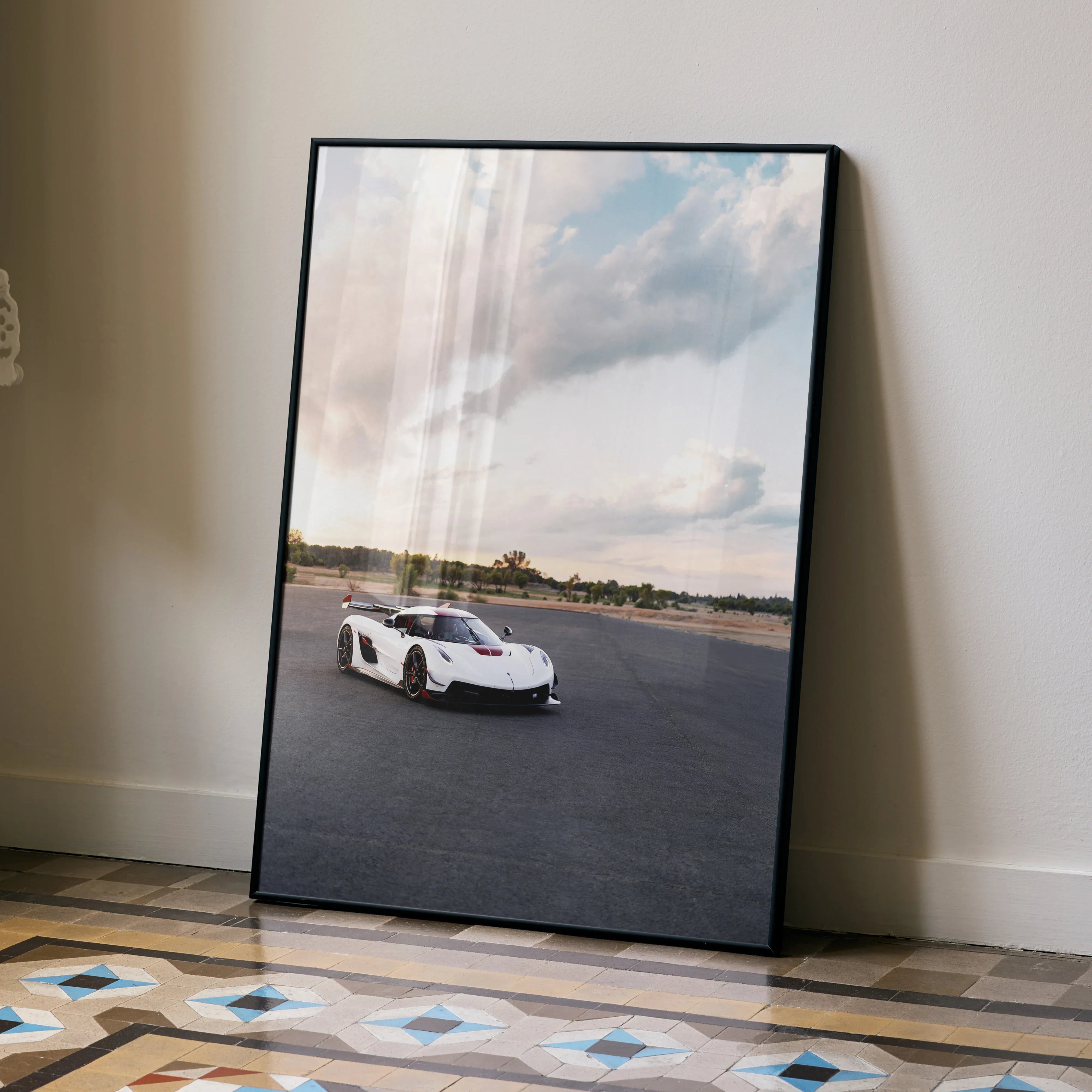 Koenigsegg Jesko poster wall art featuring white sports car on racetrack under cloudy sky.
