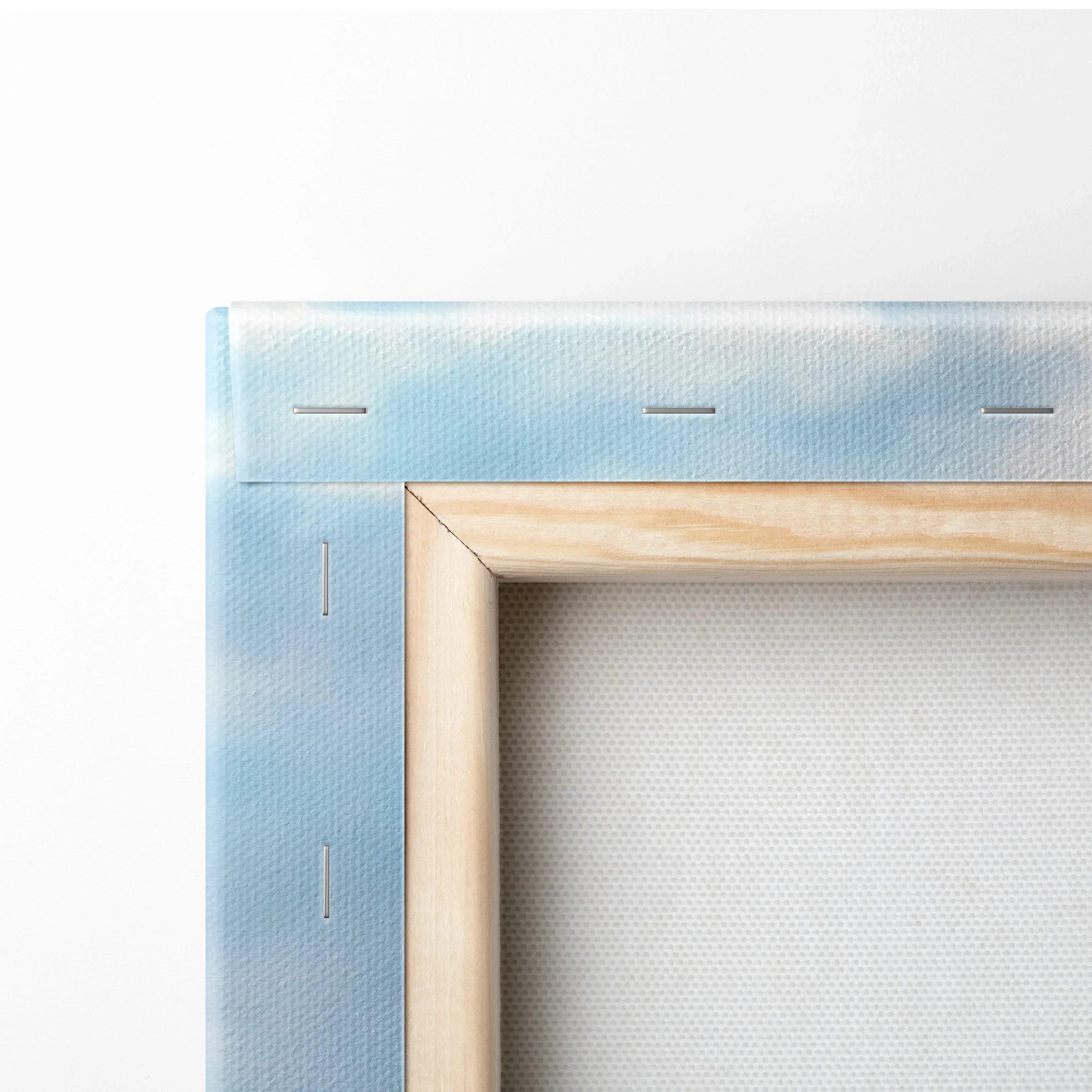 Close-up of wood-framed canvas art with light blue edge and white backing for wall art display.