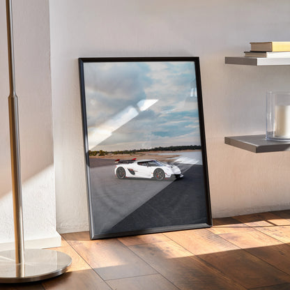 Koenigsegg Jesko white sports car poster leaning on floor as modern wall art with black frame.