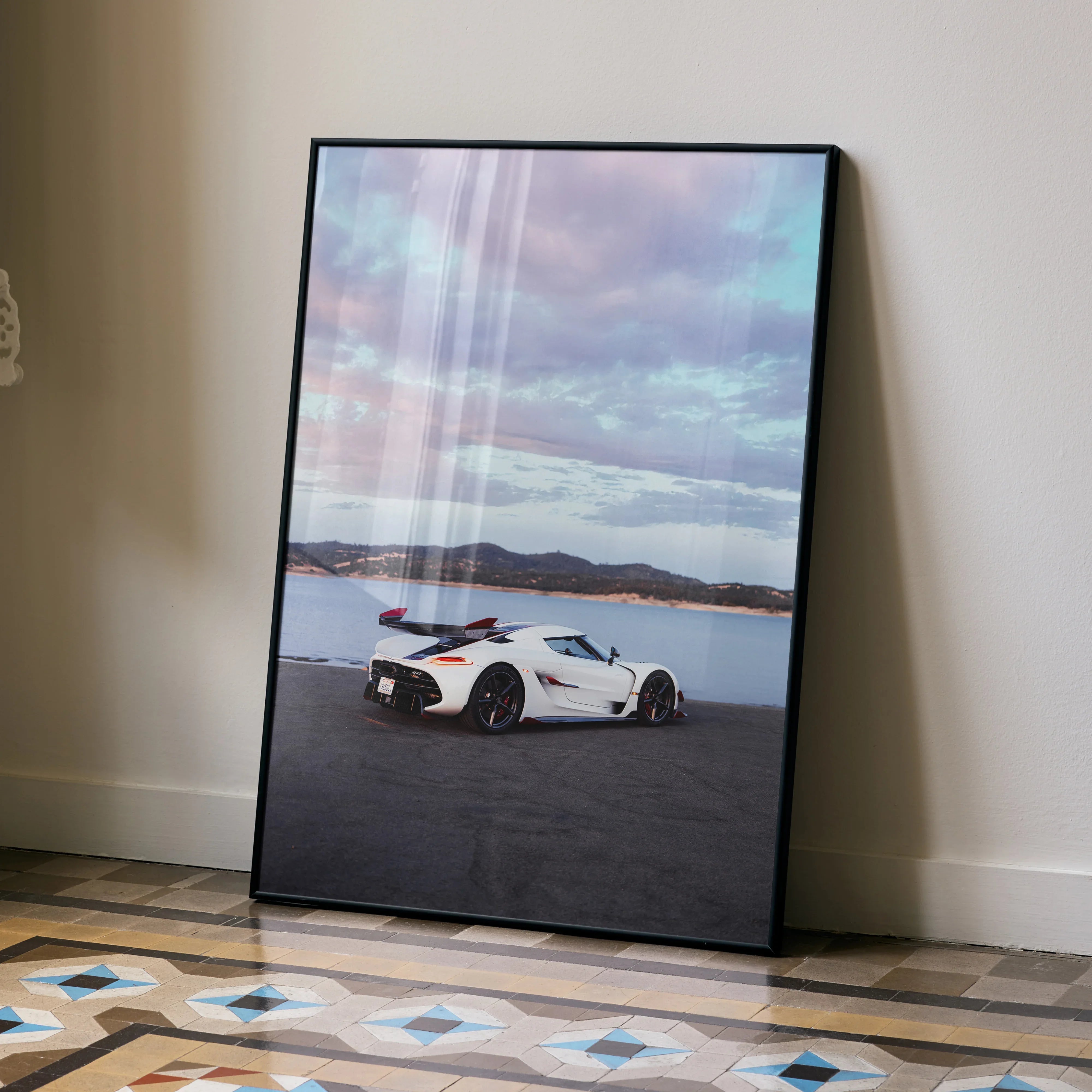 Koenigsegg Jesko white sports car poster wall art with scenic landscape and cloudy sky.