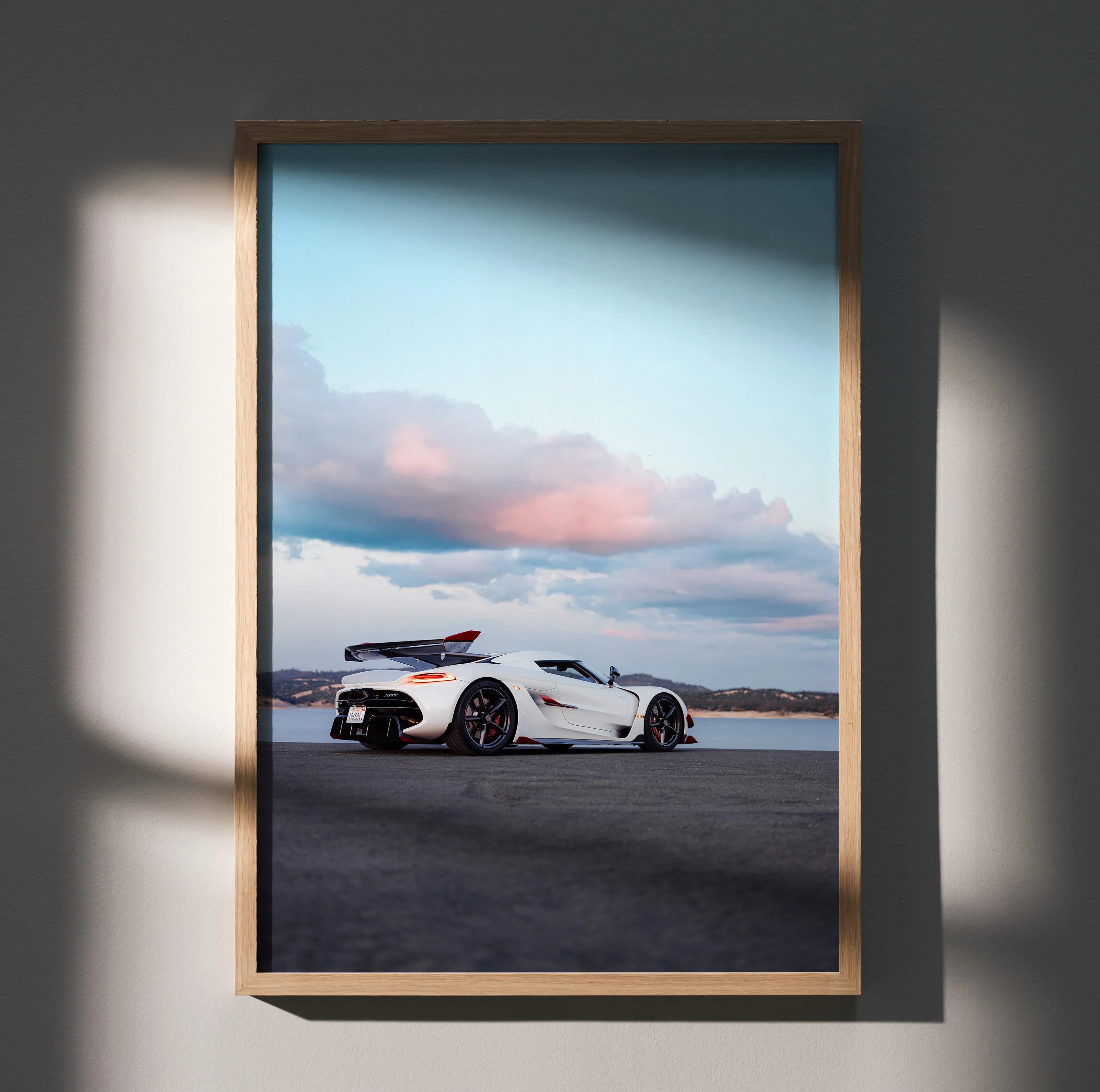 Koenigsegg Jesko sports car poster with coastal sunset sky, modern wall art in wooden frame.