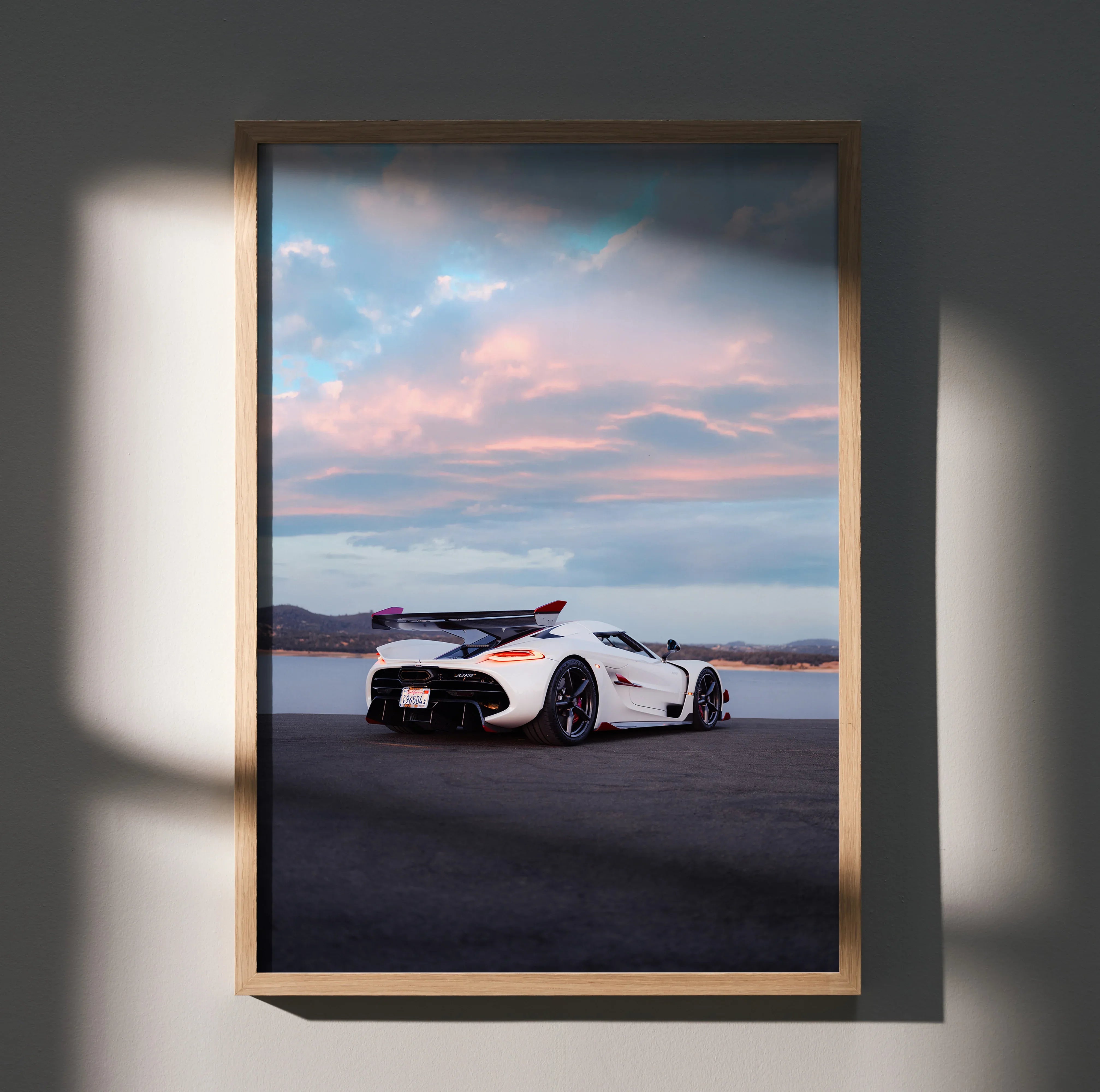 Koenigsegg Jesko poster featuring white sports car on road under pastel sunset sky wall art.