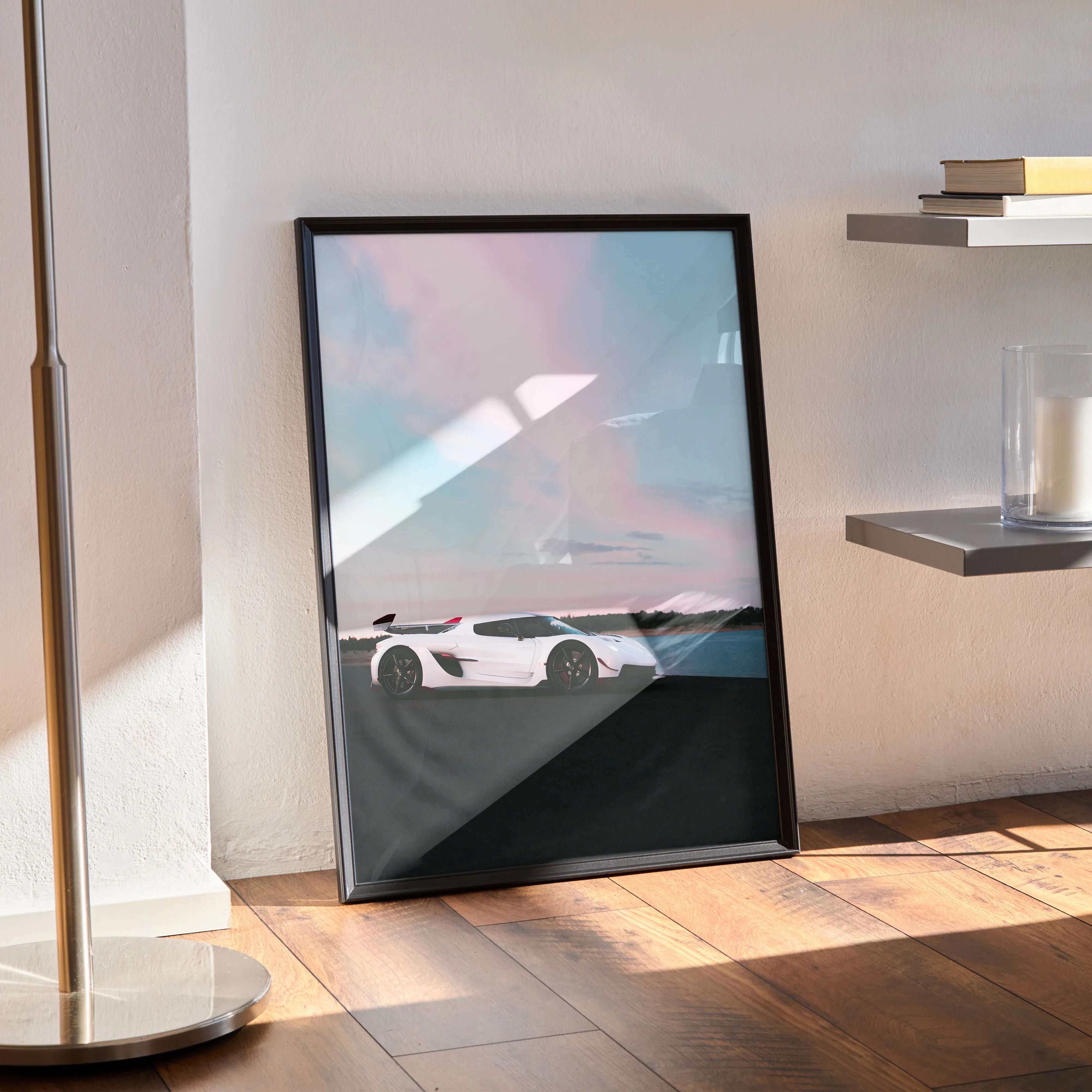 Koenigsegg Jesko white sports car poster in black frame leaning against wall on wooden floor wall art.