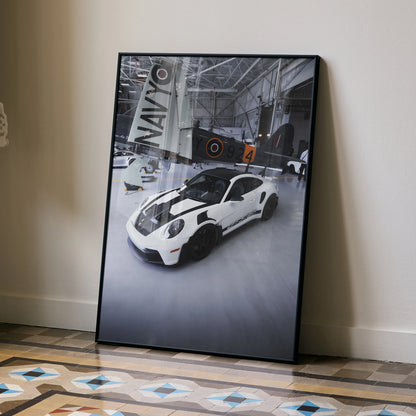 Porsche 911 GT3 RS white sports car poster leaning on wall with racing garage background wall art.