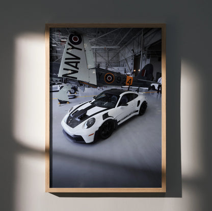 Porsche 911 GT3 RS poster with white sports car and vintage airplane background wall art.
