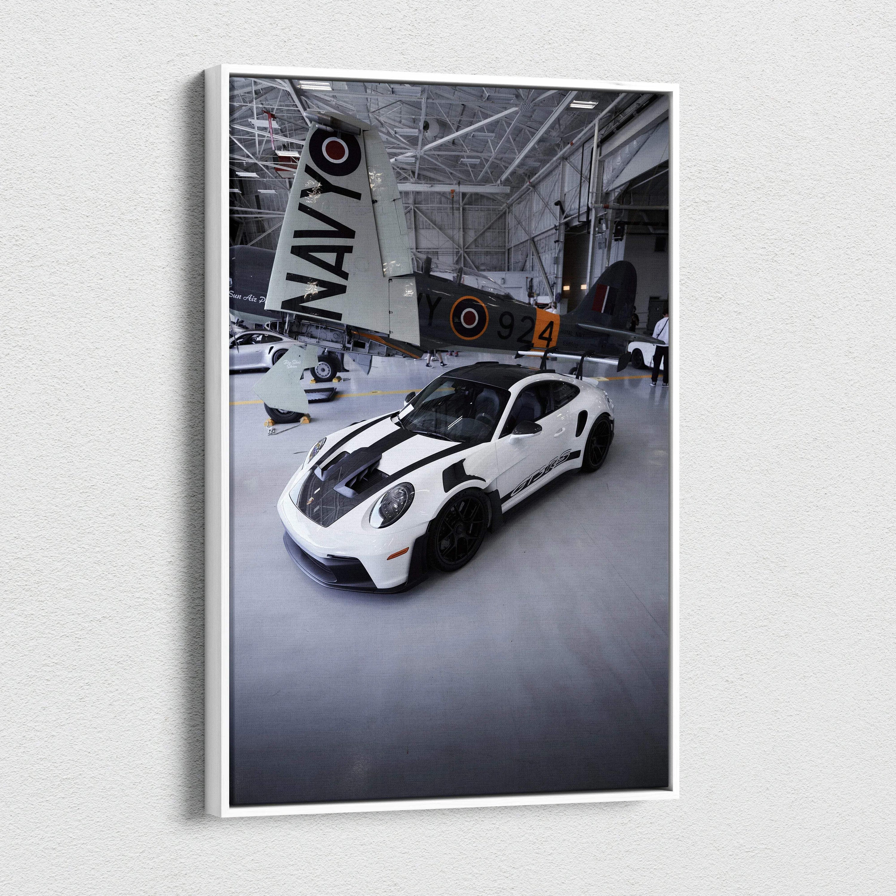 Vertical canvas art featuring a white Porsche 911 GT3RS with black stripes in a hangar setting Wall Art.