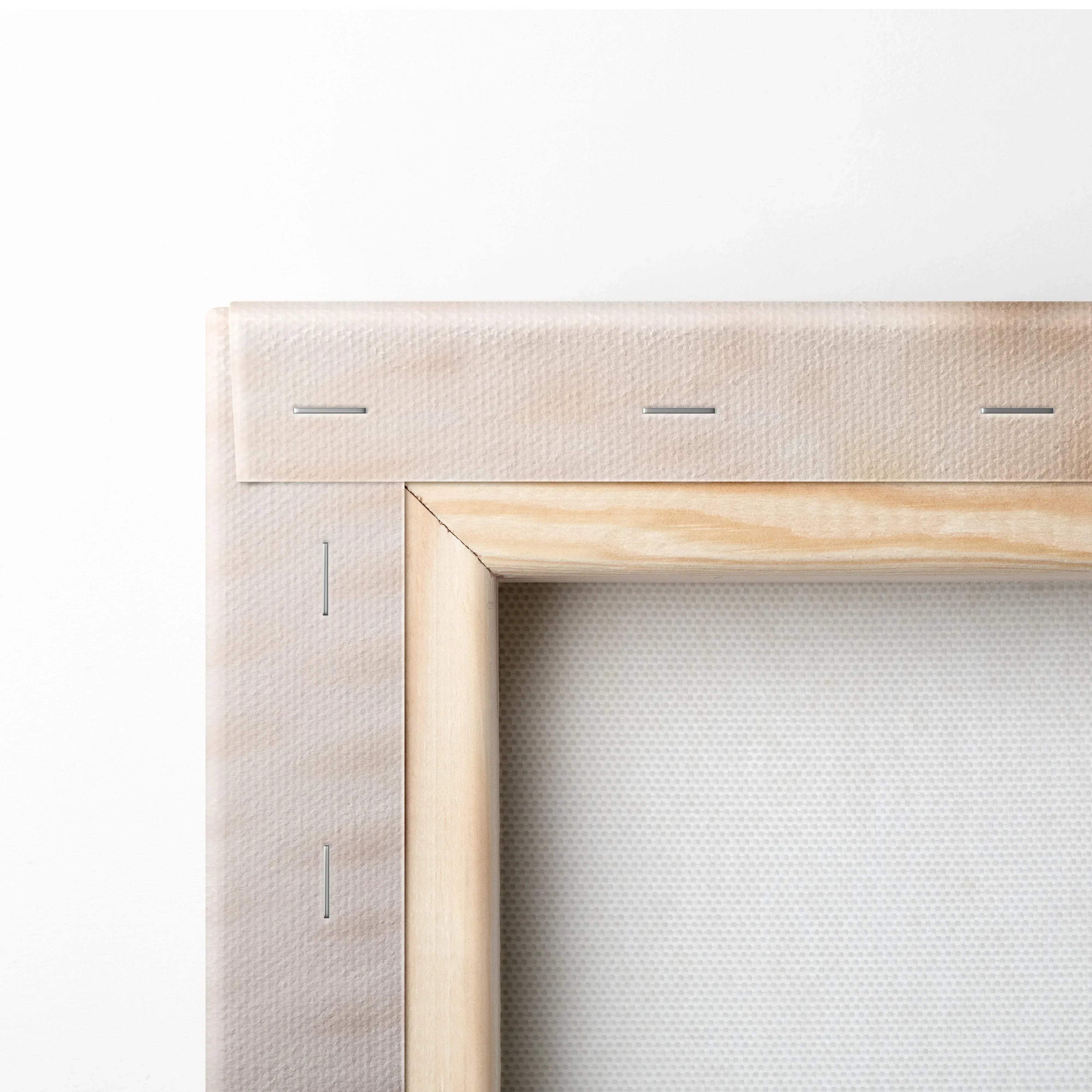 Close-up of wooden stretcher frame and stapled beige canvas fabric for wall art decor.