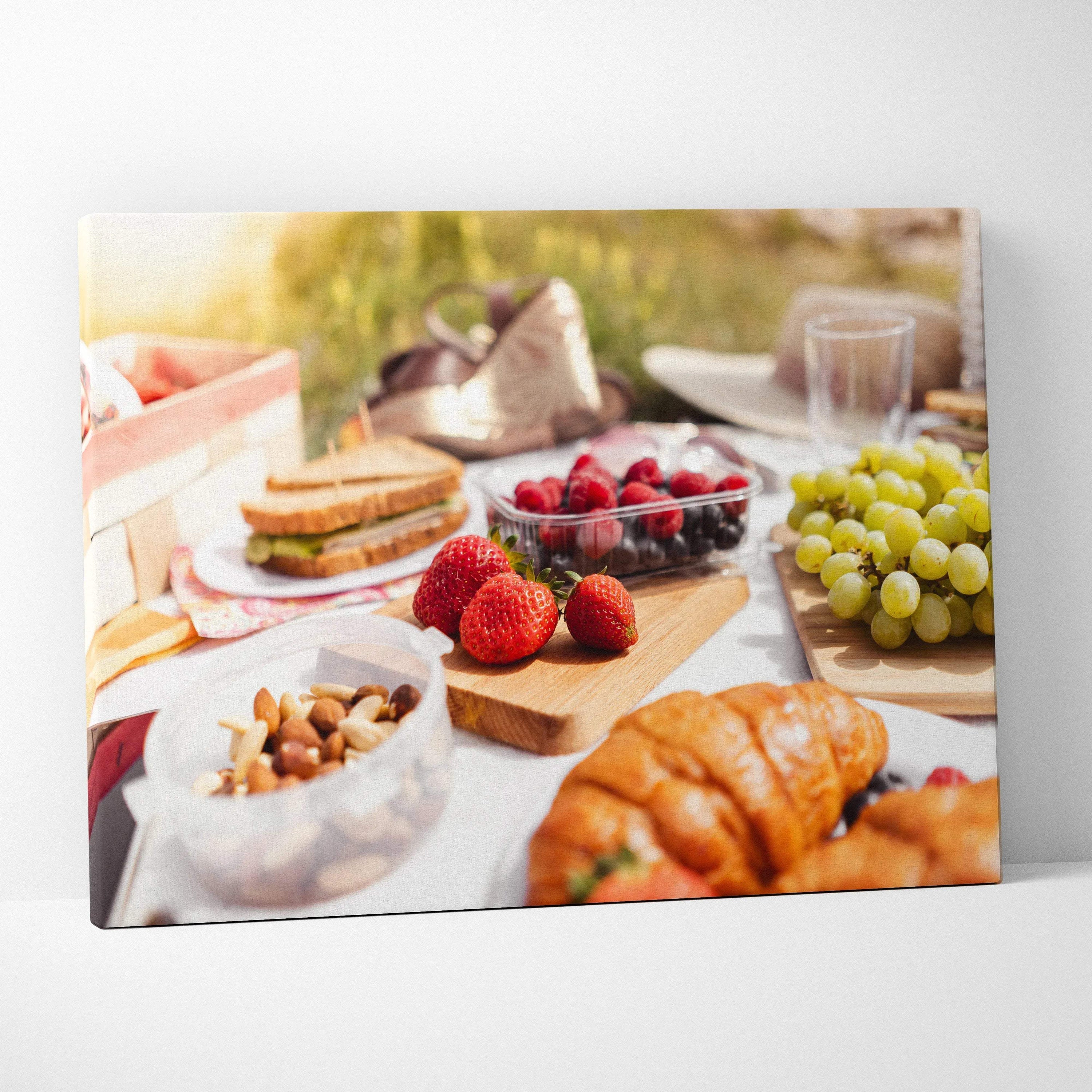High-resolution canvas wall art featuring fresh strawberries, grapes, croissants, and nuts on a rustic lunch table.