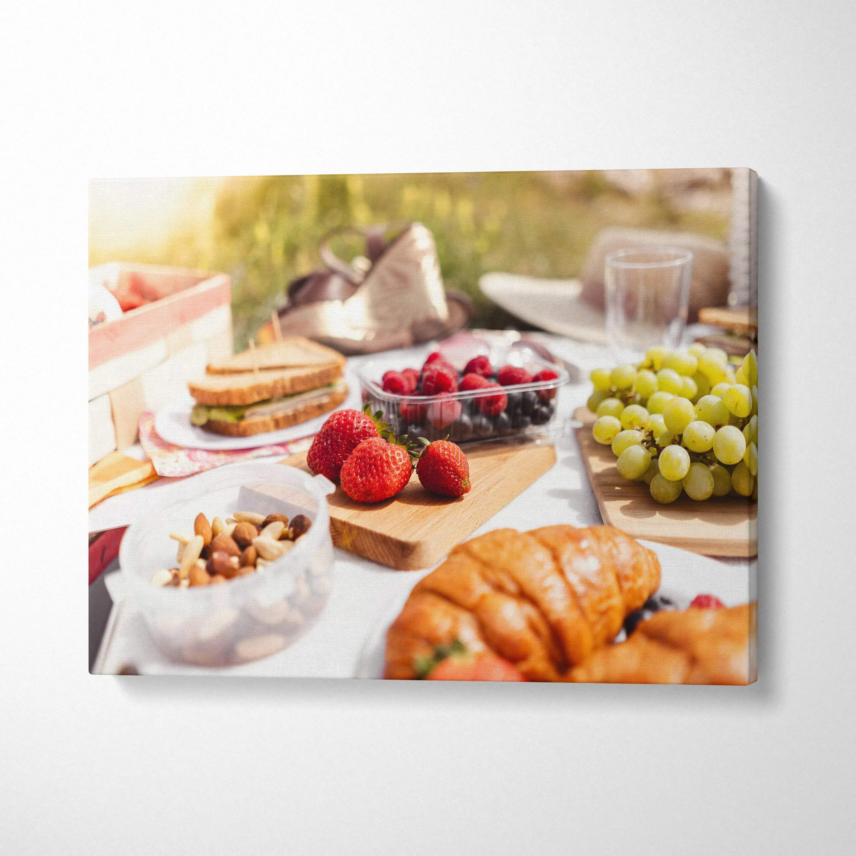 Canvas wall art featuring fresh strawberries, grapes, croissants, and nuts on a sunlit lunch table decor.
