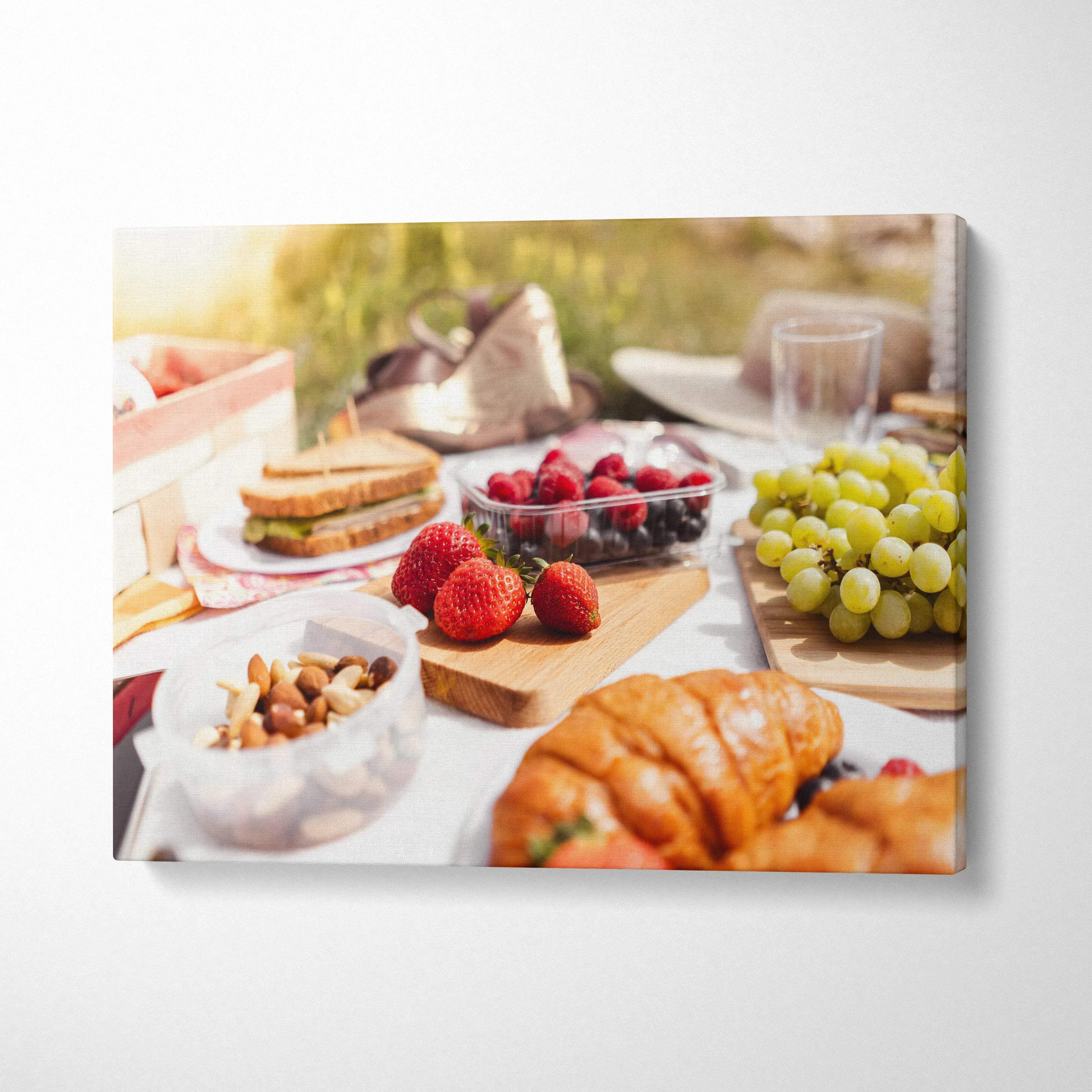 Canvas wall art featuring fresh strawberries, grapes, croissants, and nuts on a sunlit lunch table decor.