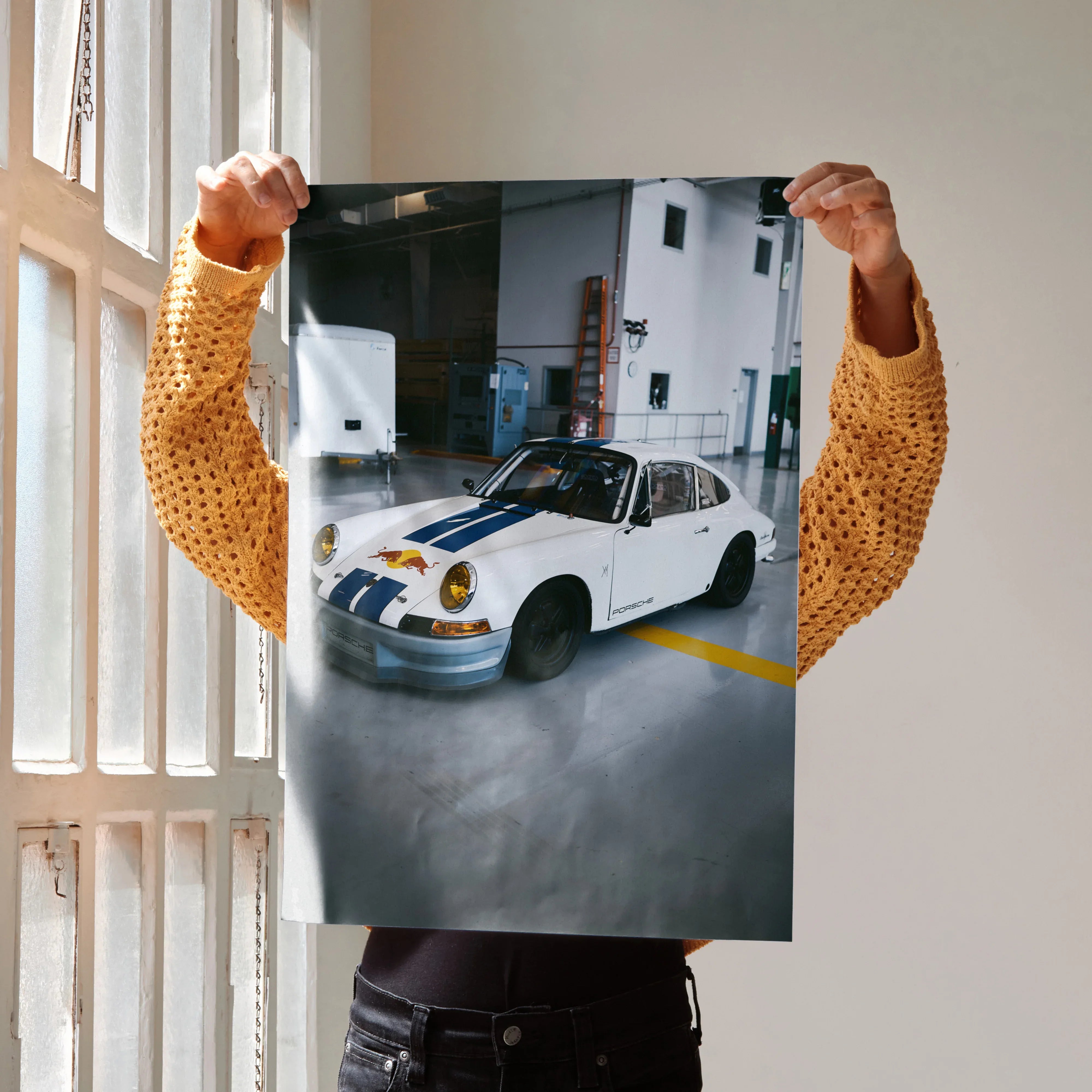 Porsche 911 classic white car poster held indoors, high-resolution wall art with urban garage background.