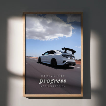 Motivational poster wall art featuring a white Subaru WRX STI racing on a road under a blue sky with clouds, text "Strive.