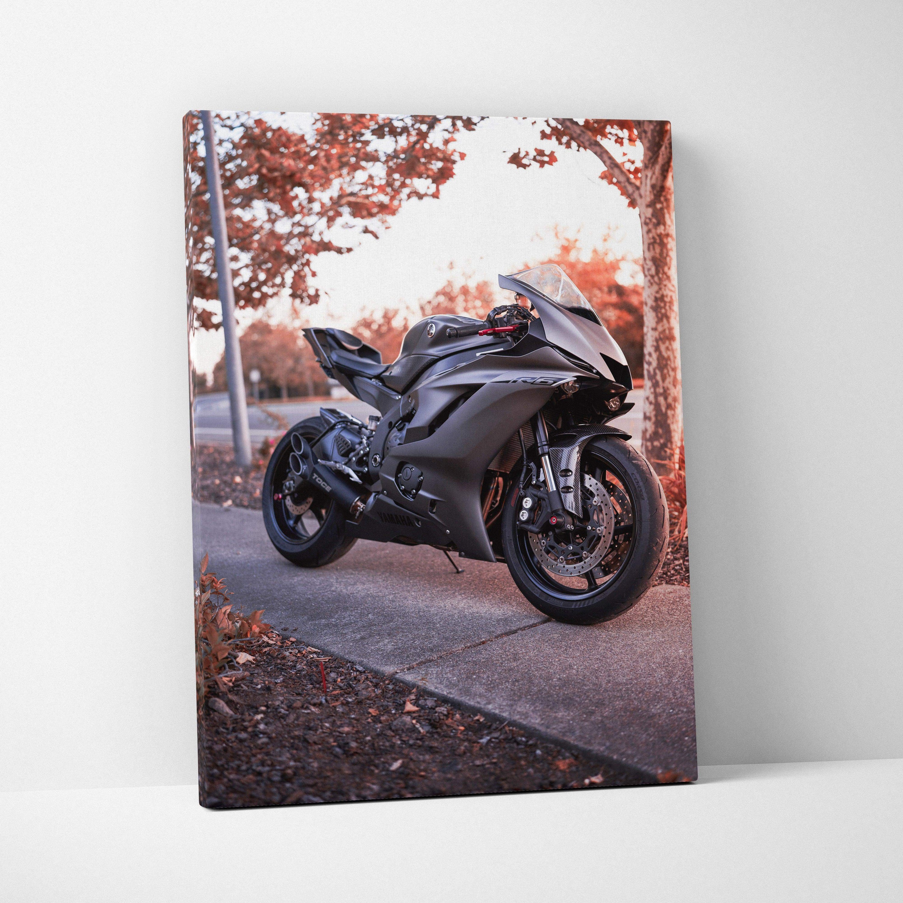 Matte black Yamaha R6 motorcycle on tree-lined road canvas wall art in vertical format.