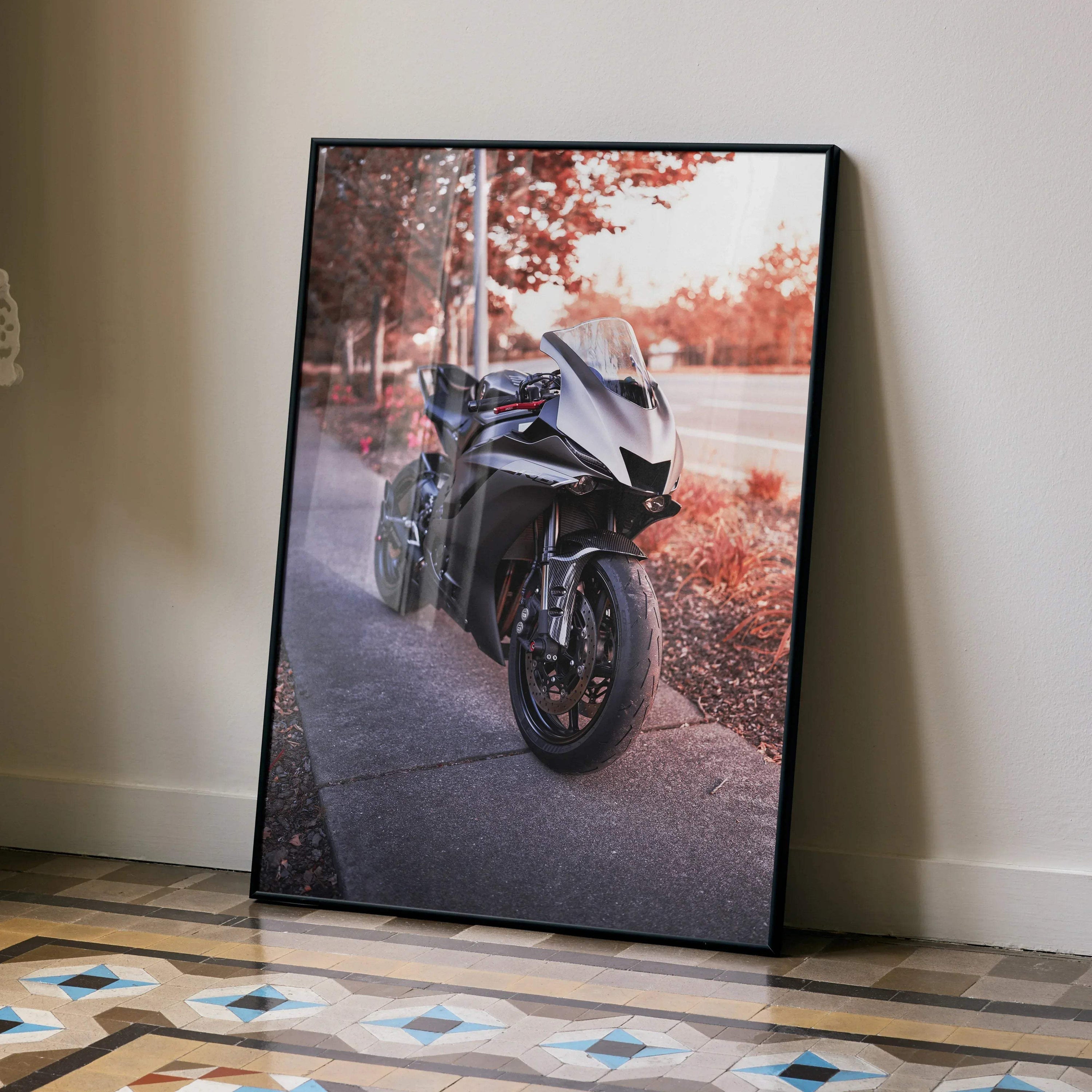 Yamaha R6 motorcycle poster with black frame leaning against wall, showcasing sleek sport bike on sidewalk wall art.