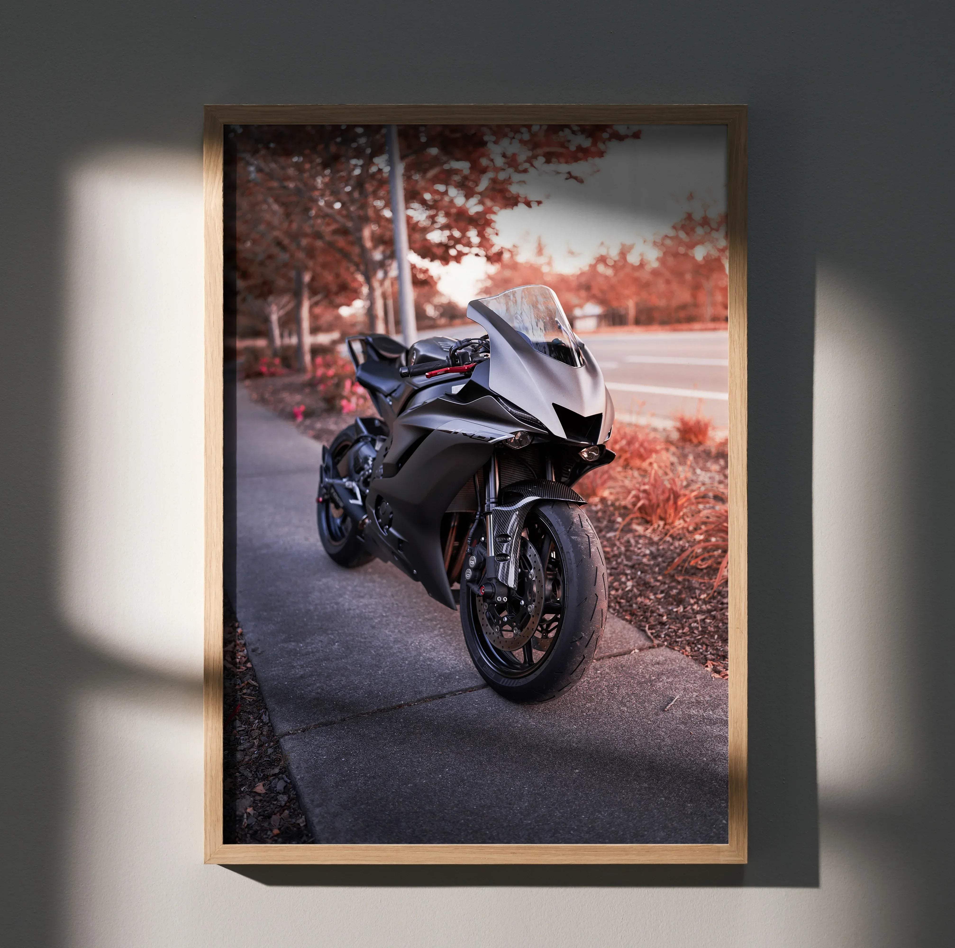 A sleek black and silver Yamaha R6 sport motorcycle art print in a light wood frame to elevate your space with style