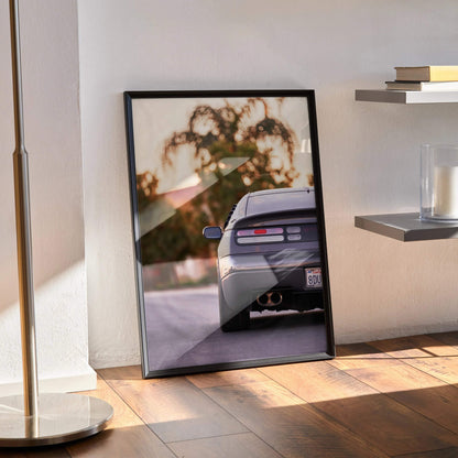 Nissan 300ZX rear view poster wall art with sunset and blurred trees in black frame.