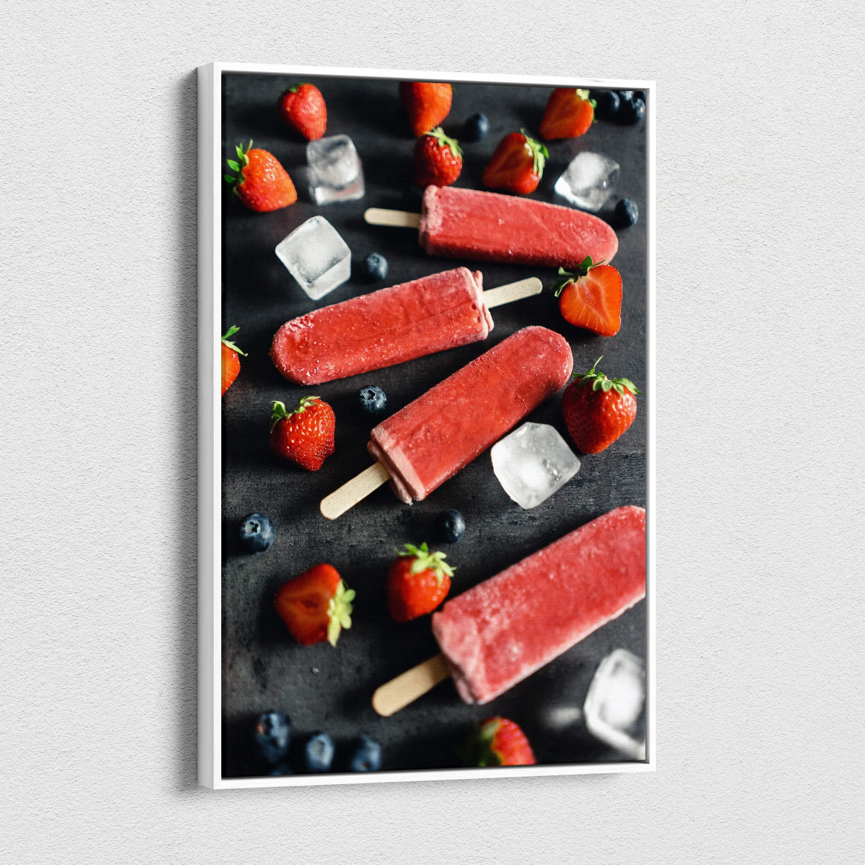 Canvas wall art featuring vibrant red strawberry popsicles with fresh strawberries, blueberries, and ice cubes on a dark.