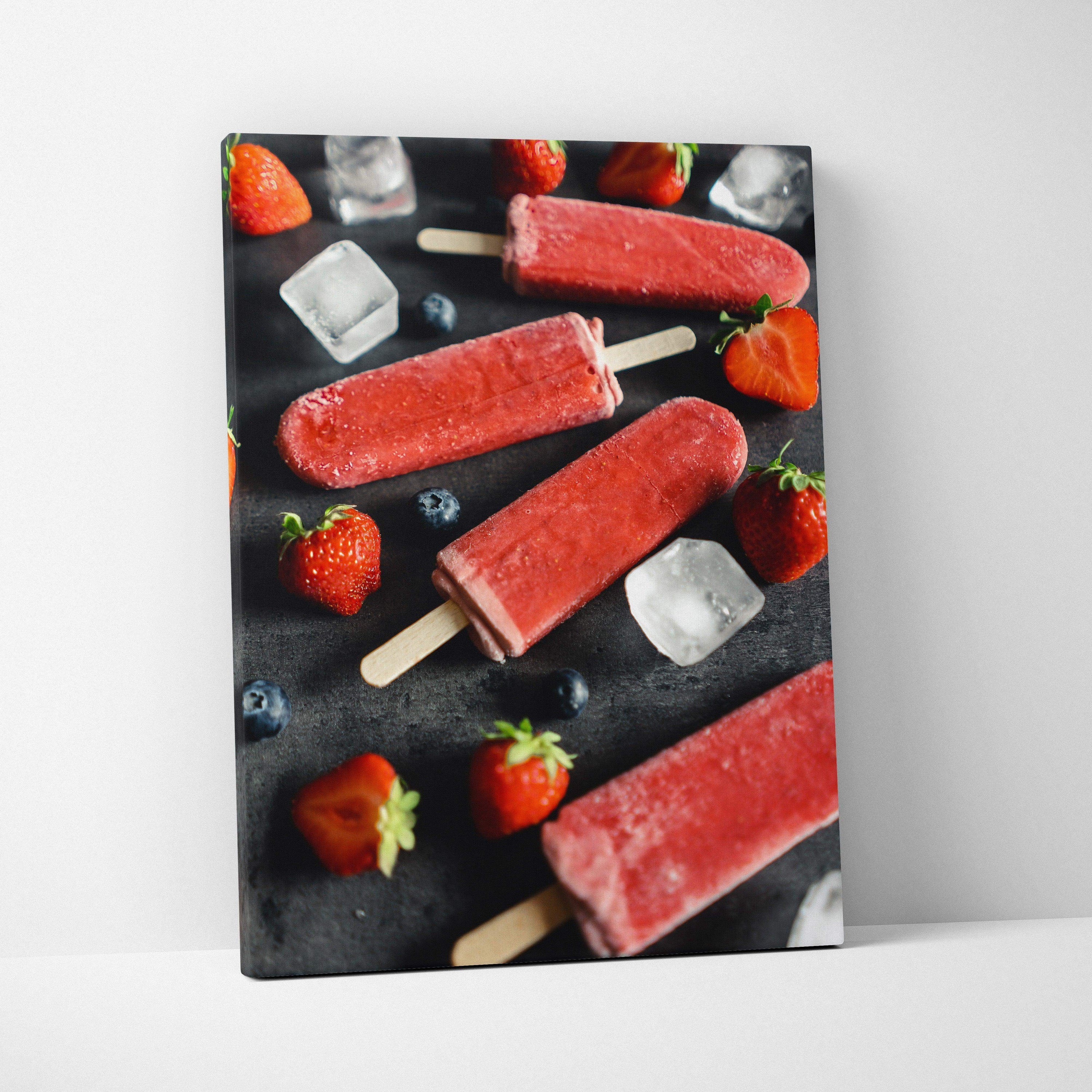 Canvas wall art featuring vibrant red strawberry popsicles with scattered fresh strawberries and ice cubes on a dark.