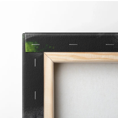 Close-up of canvas wall art with black-stretched fabric and natural wood frame edges.