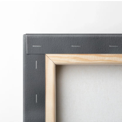 Close-up of stretched canvas wall art corner with wooden frame and black backing for modern decor.