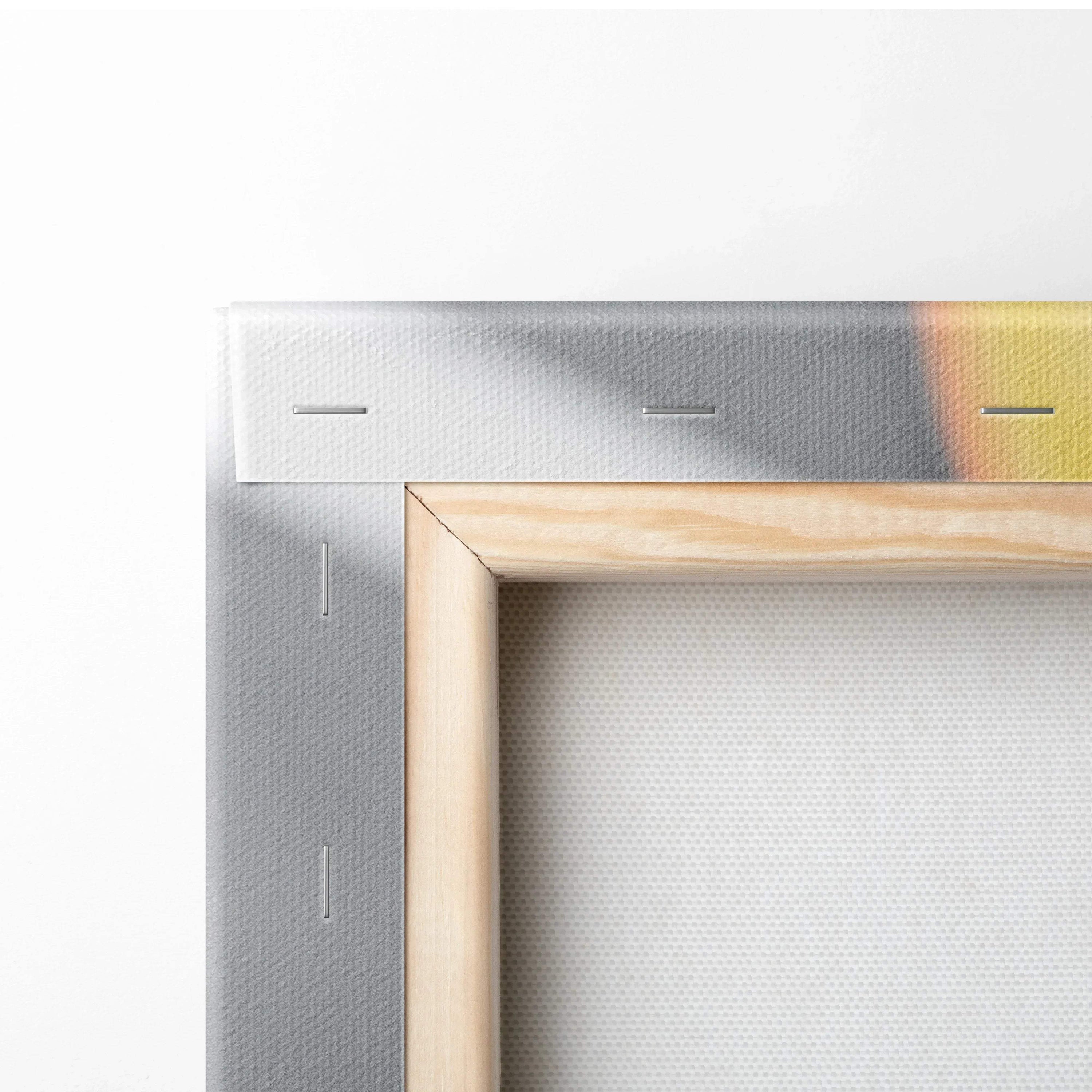 Close-up of wooden stretcher bars framing a canvas with stapled edges and a hint of bright orange and gray paint on the.