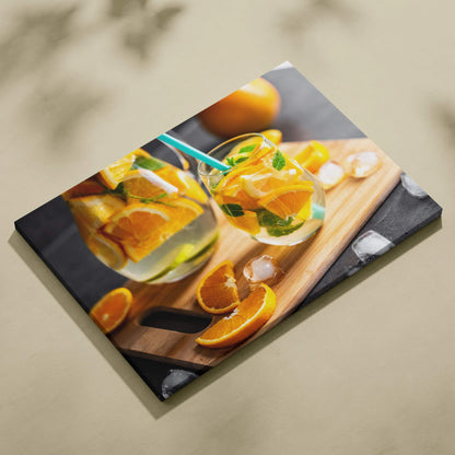 Canvas wall art featuring vibrant sliced oranges in glasses with herbs, bright and colorful kitchen decor.