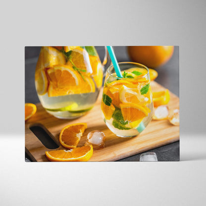 Canvas wall art featuring vibrant sliced oranges in a glass with a straw, styled for modern kitchen decor.