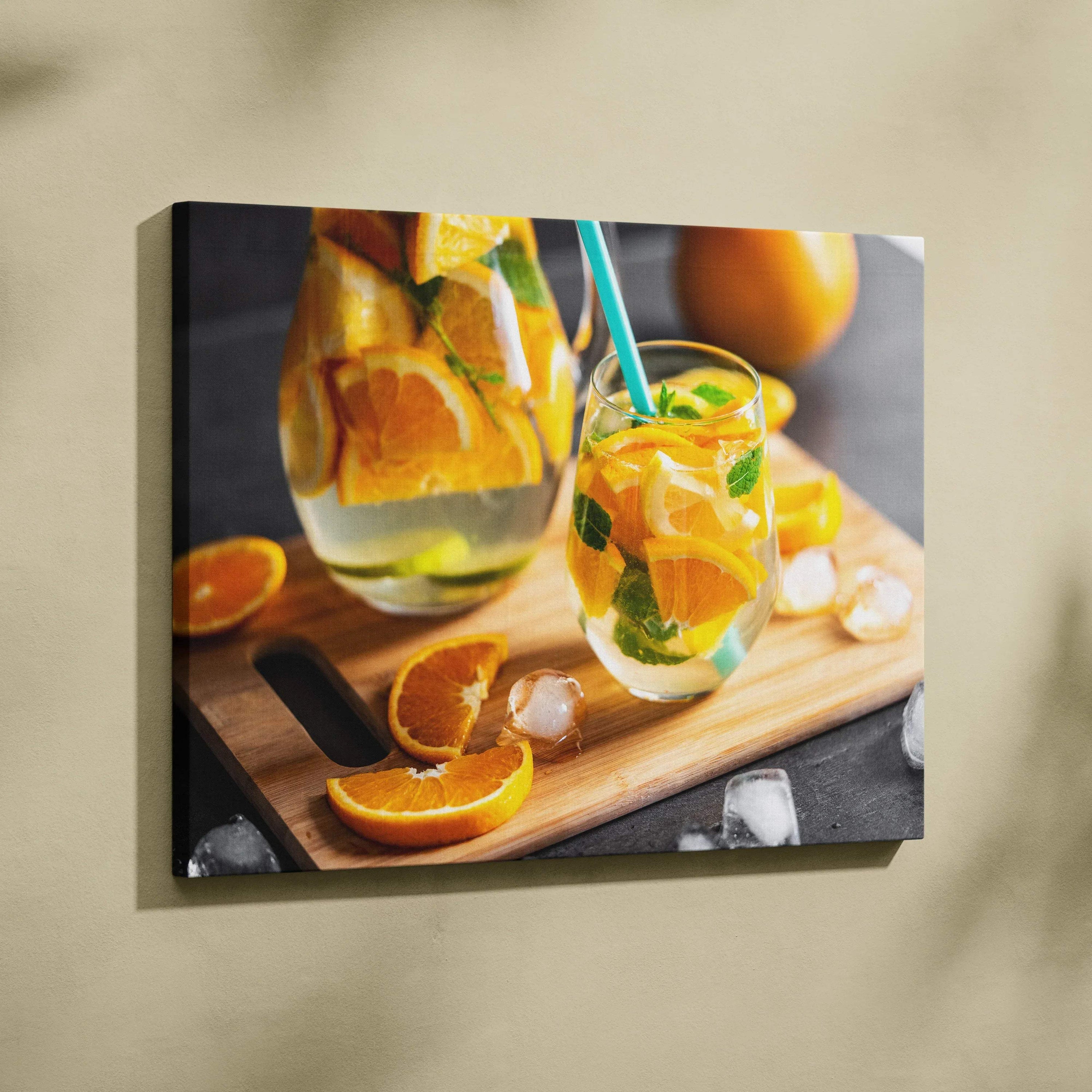 Canvas wall art featuring vibrant sliced oranges in a glass pitcher and mason jar with mint on a wooden board.