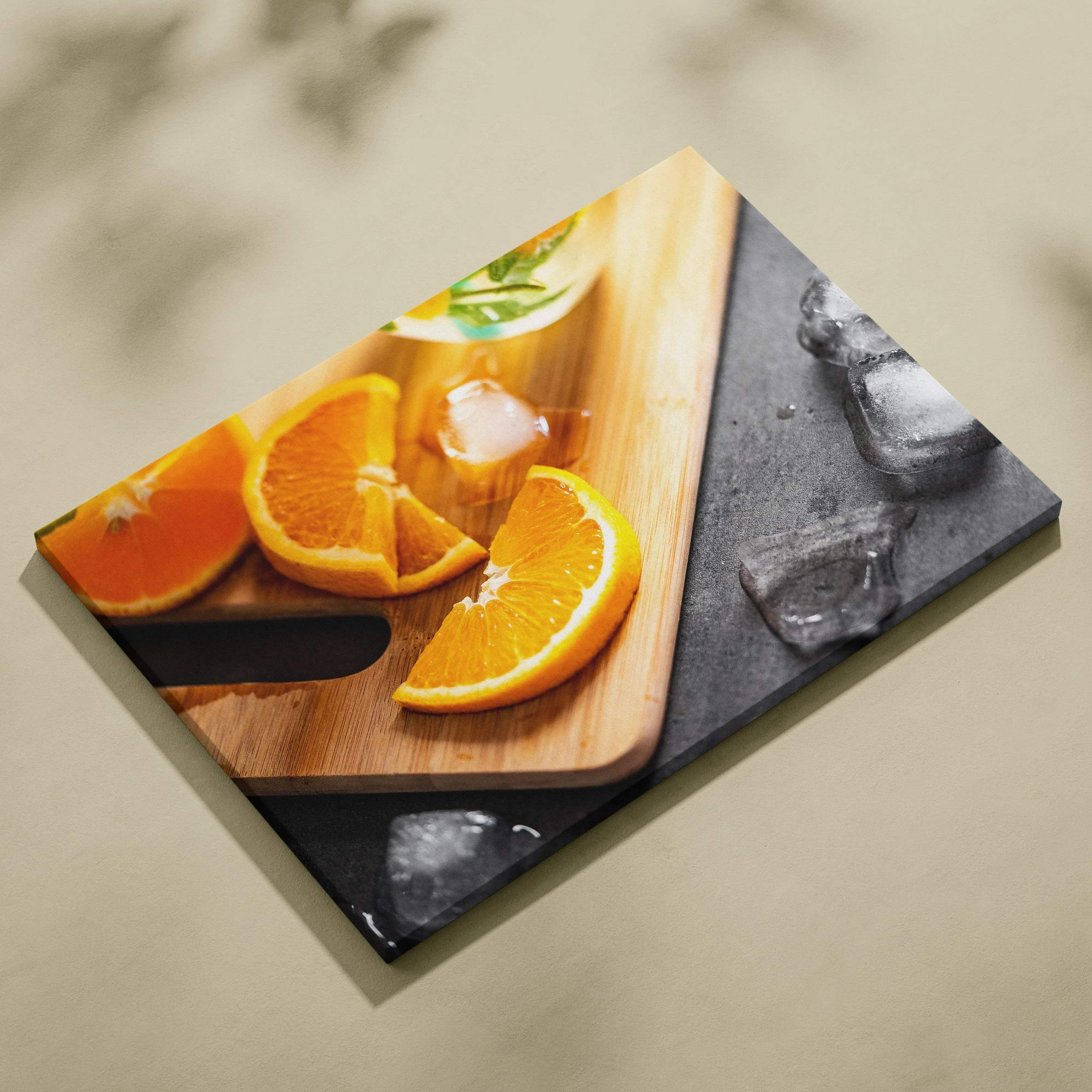 Canvas wall art featuring vibrant sliced oranges on a wooden cutting board with ice cubes and a glass, perfect for fresh.