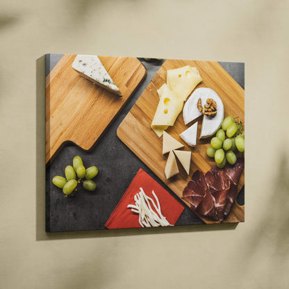 Canvas wall art featuring cheese wedges, round brie, grapes, cured meats, and nuts on wooden boards with a dark background.