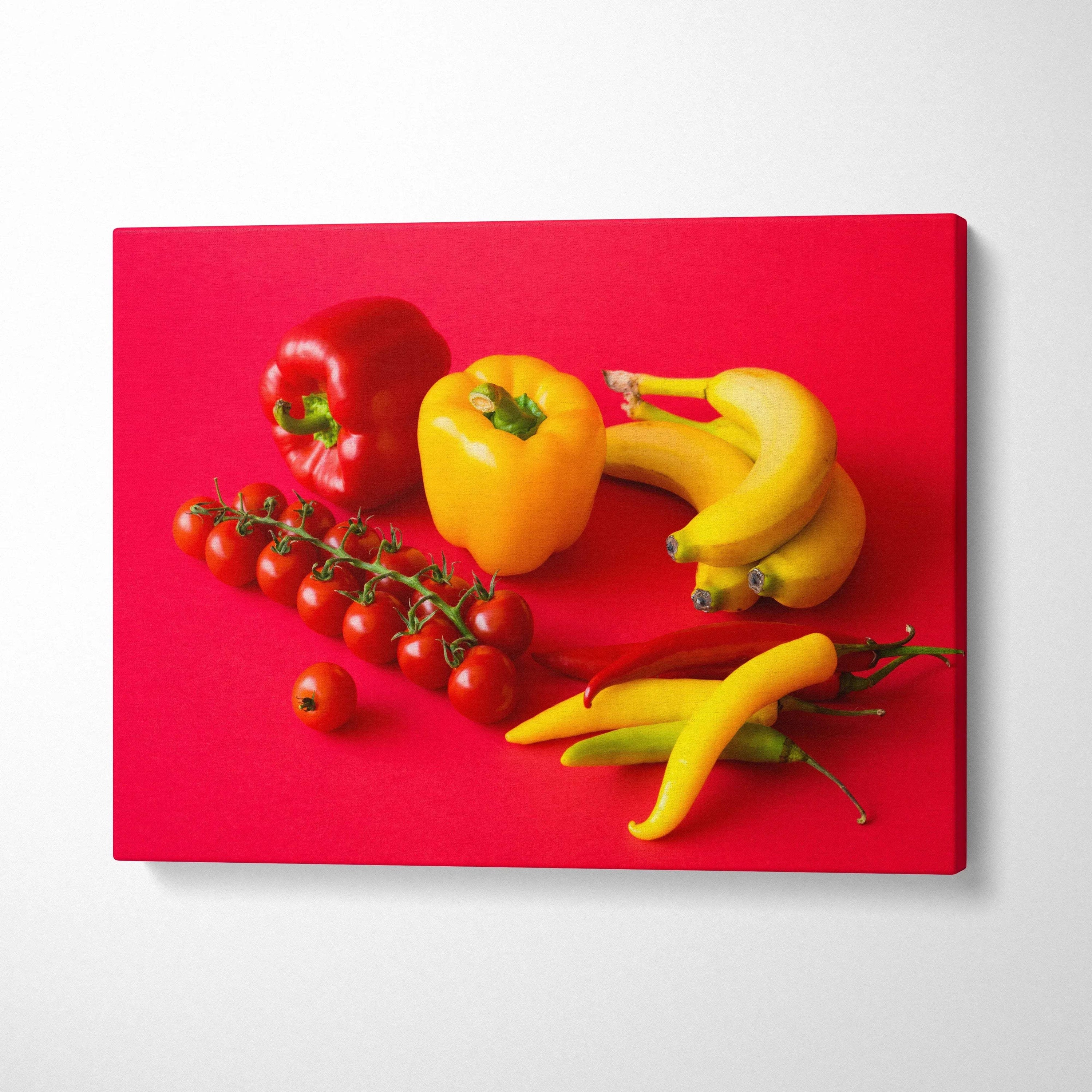 Canvas wall art featuring vibrant red and yellow peppers, bananas, and cherry tomatoes on a bold red background decor.