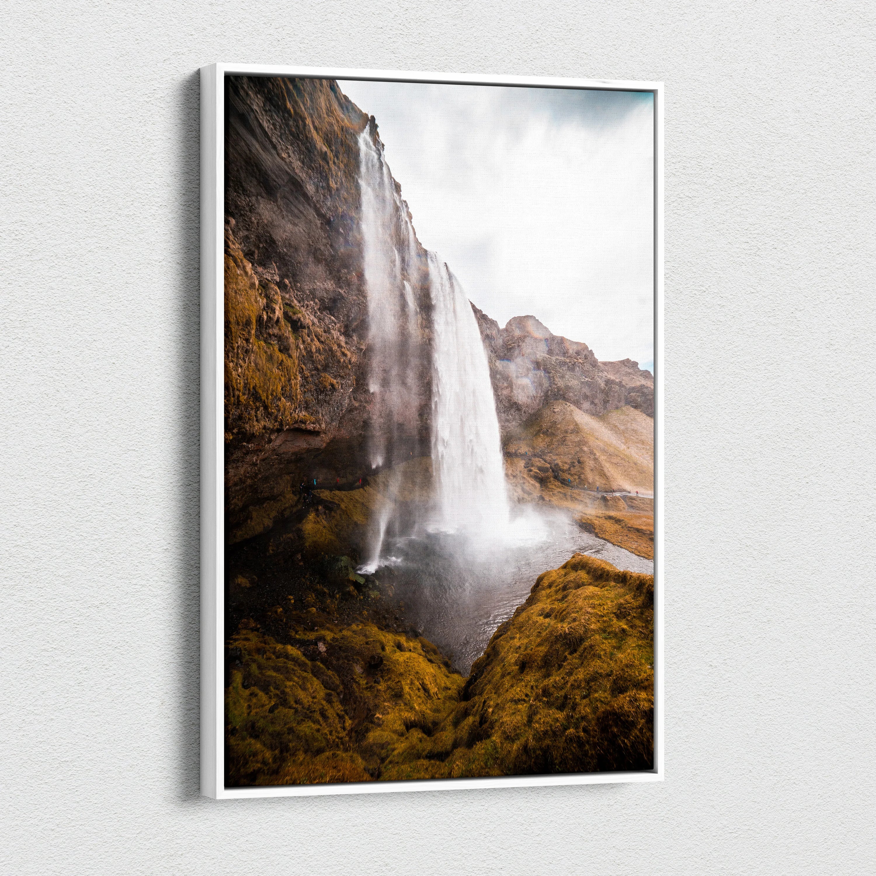 Canvas wall art featuring a tall Icelandic waterfall cascading over rocky cliffs with mossy greenery.