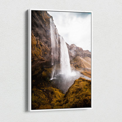 Canvas wall art featuring a tall Icelandic waterfall cascading over rocky cliffs with mossy greenery.