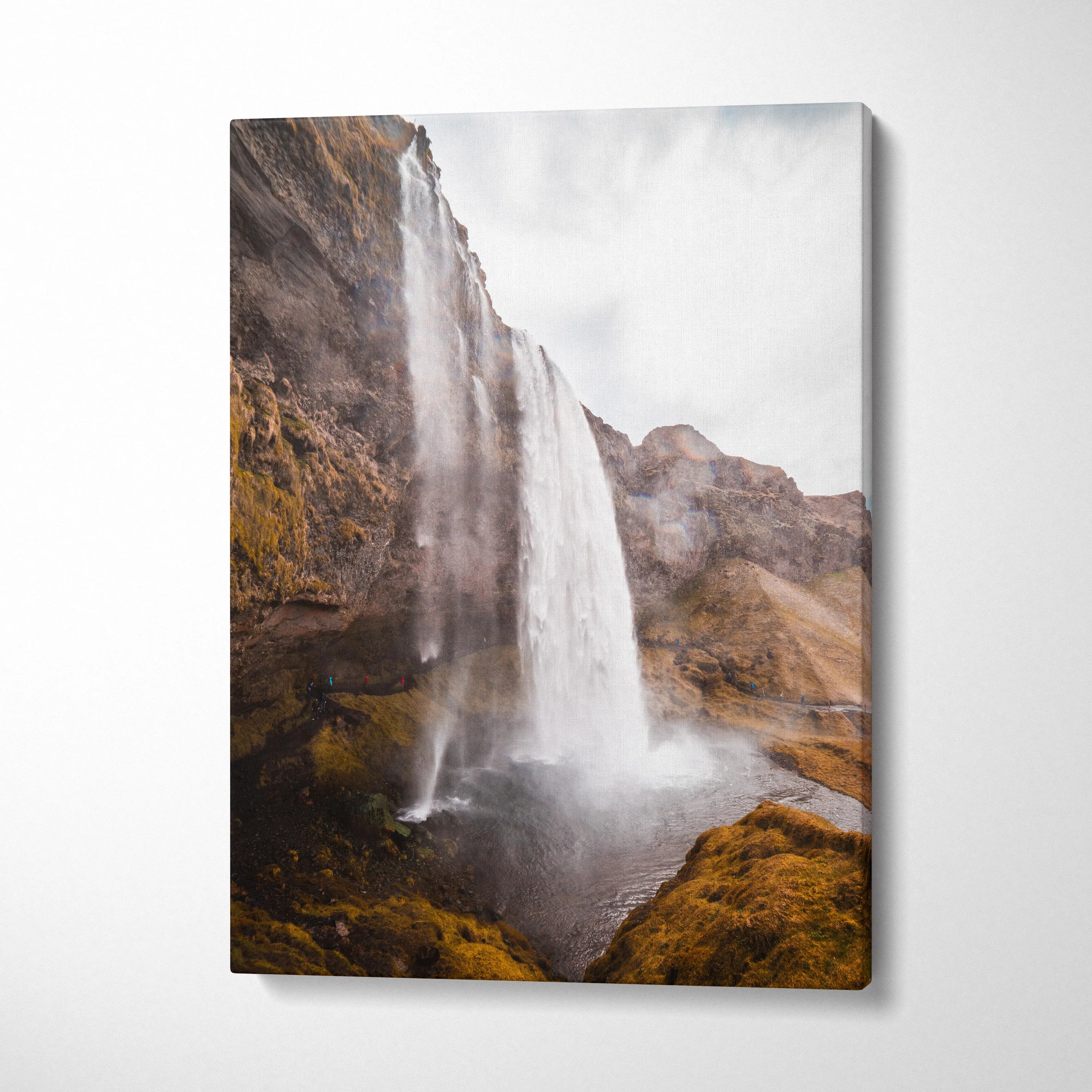 Vertical canvas wall art featuring a high-resolution Iceland waterfall landscape in earthy brown and gray tones.